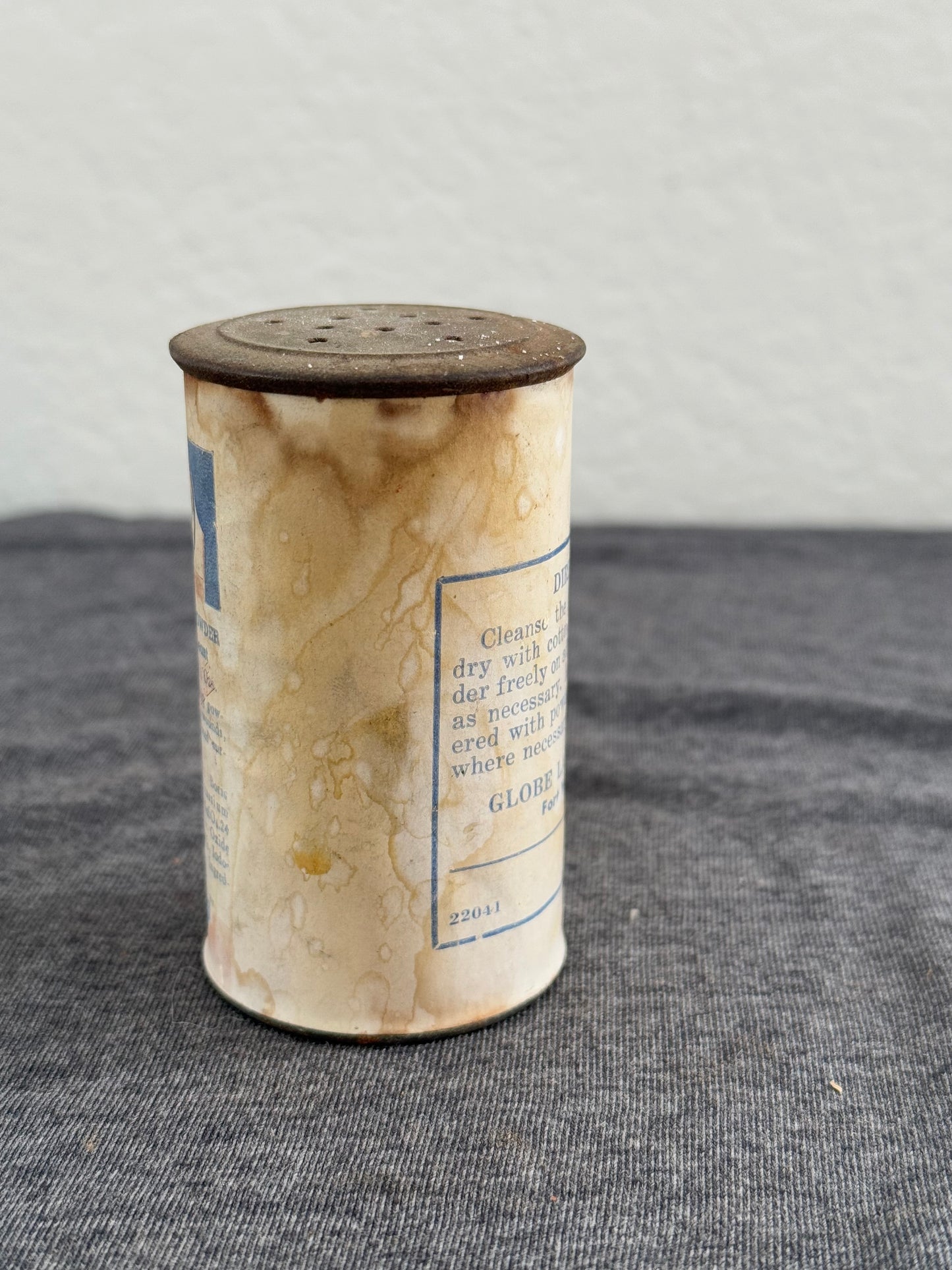 Cylindrical container with text on a gray surface