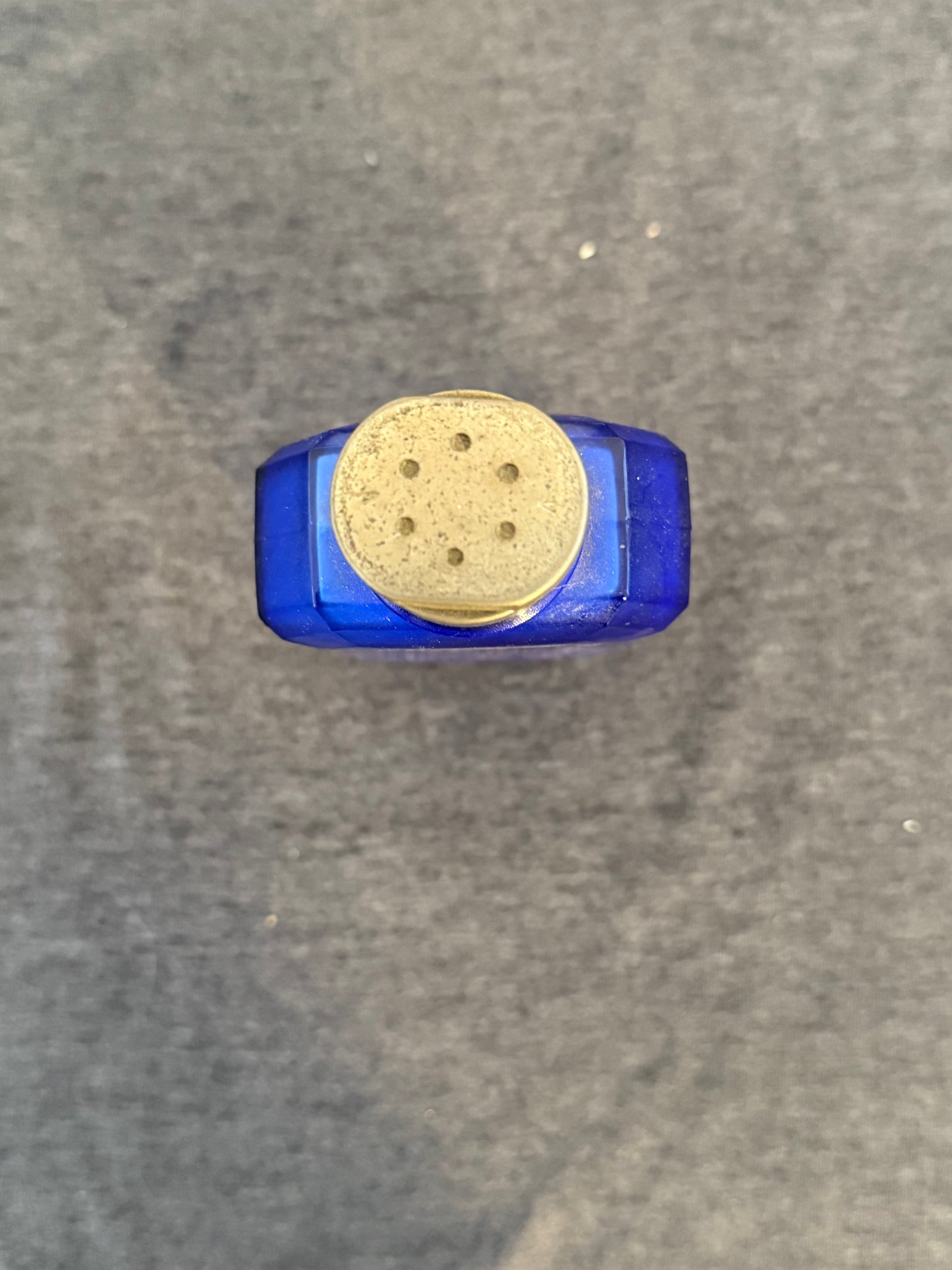 Blue and gold cylindrical object on a gray surface