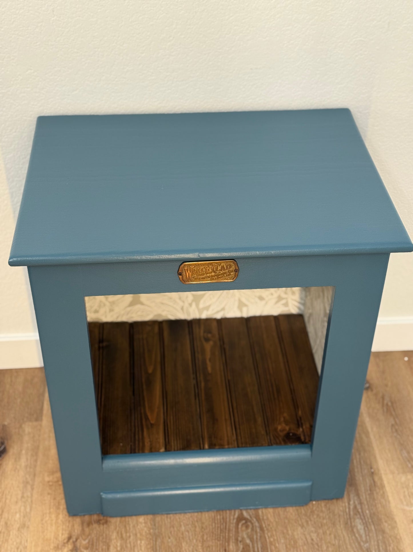Blue wooden side table with a wood floor.