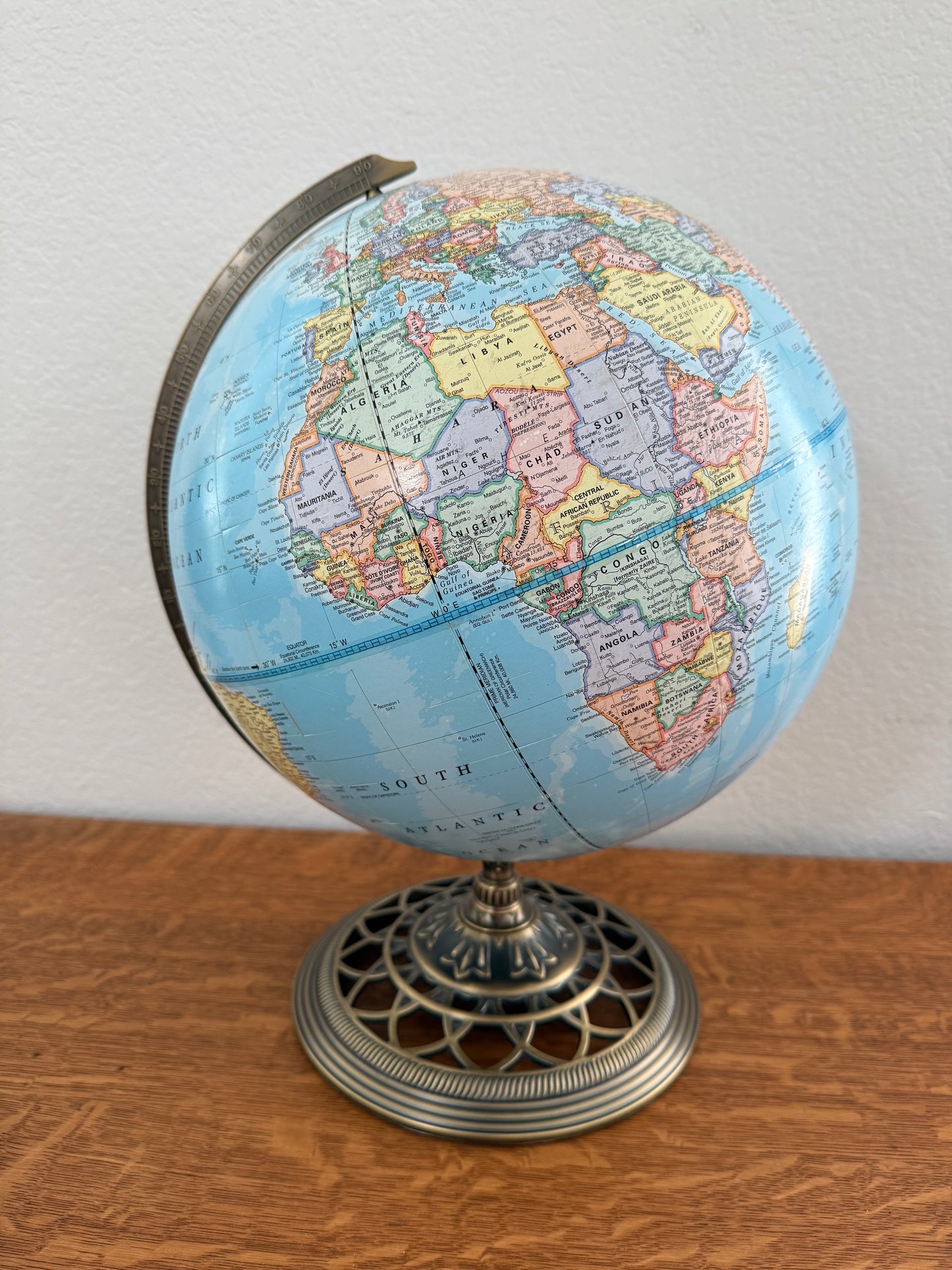 Globe on a wooden table with white wall background