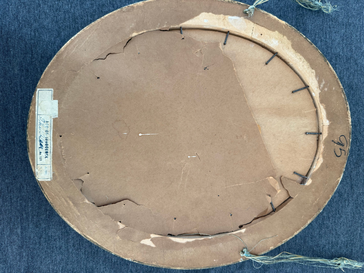Round cardboard piece with blue thread and a label on a blue background