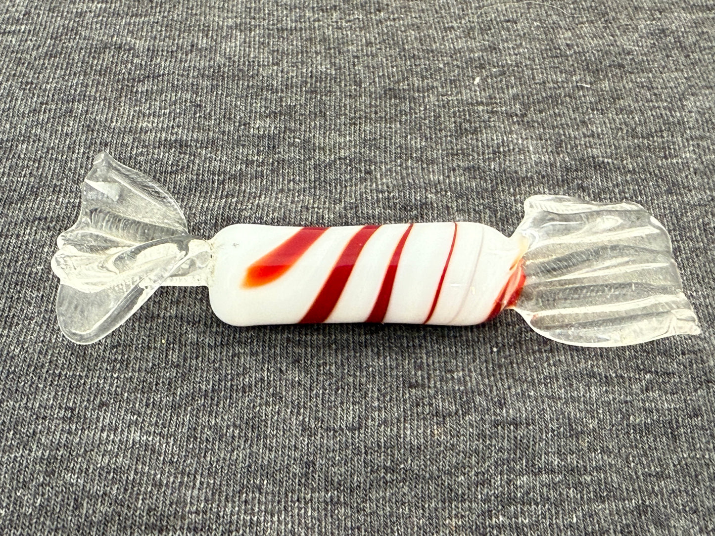 Glass candy with red and white stripes on a gray background
