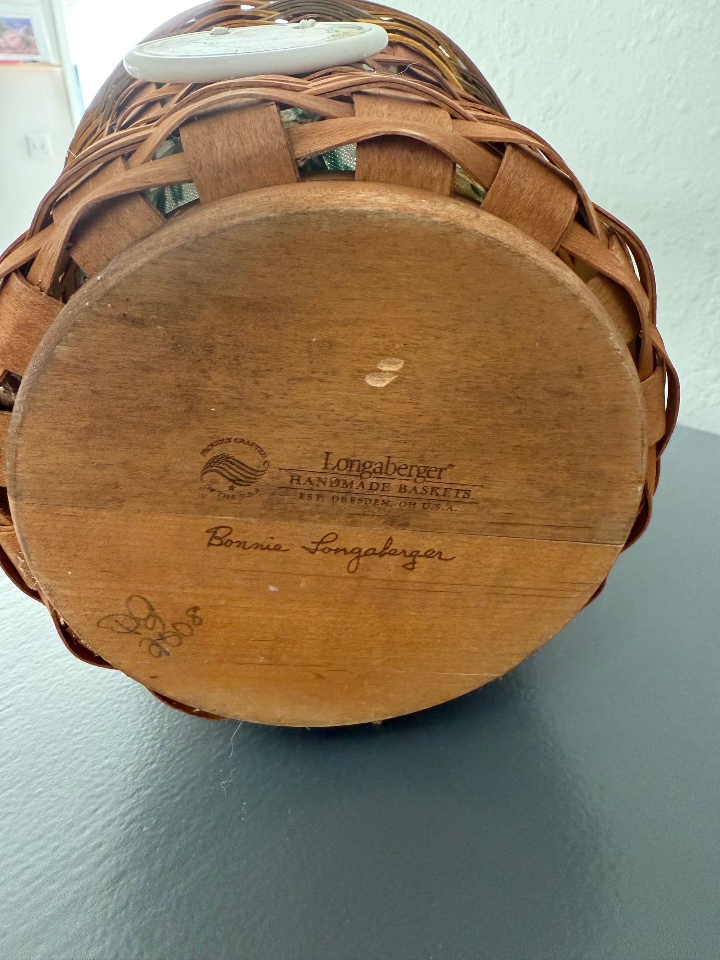 Wooden basket with a visible brand logo on a light gray background