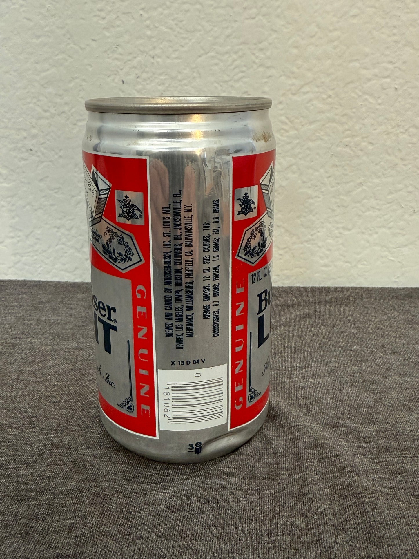 Beer can with red and white label on a gray surface