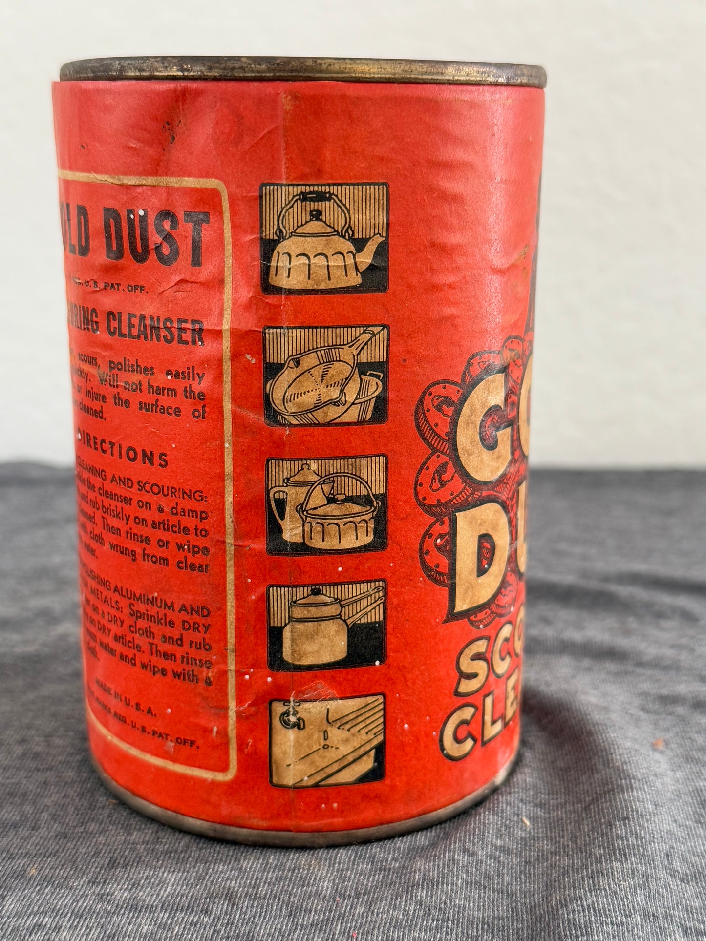 Vintage red can with gold and black text and graphics on a gray background