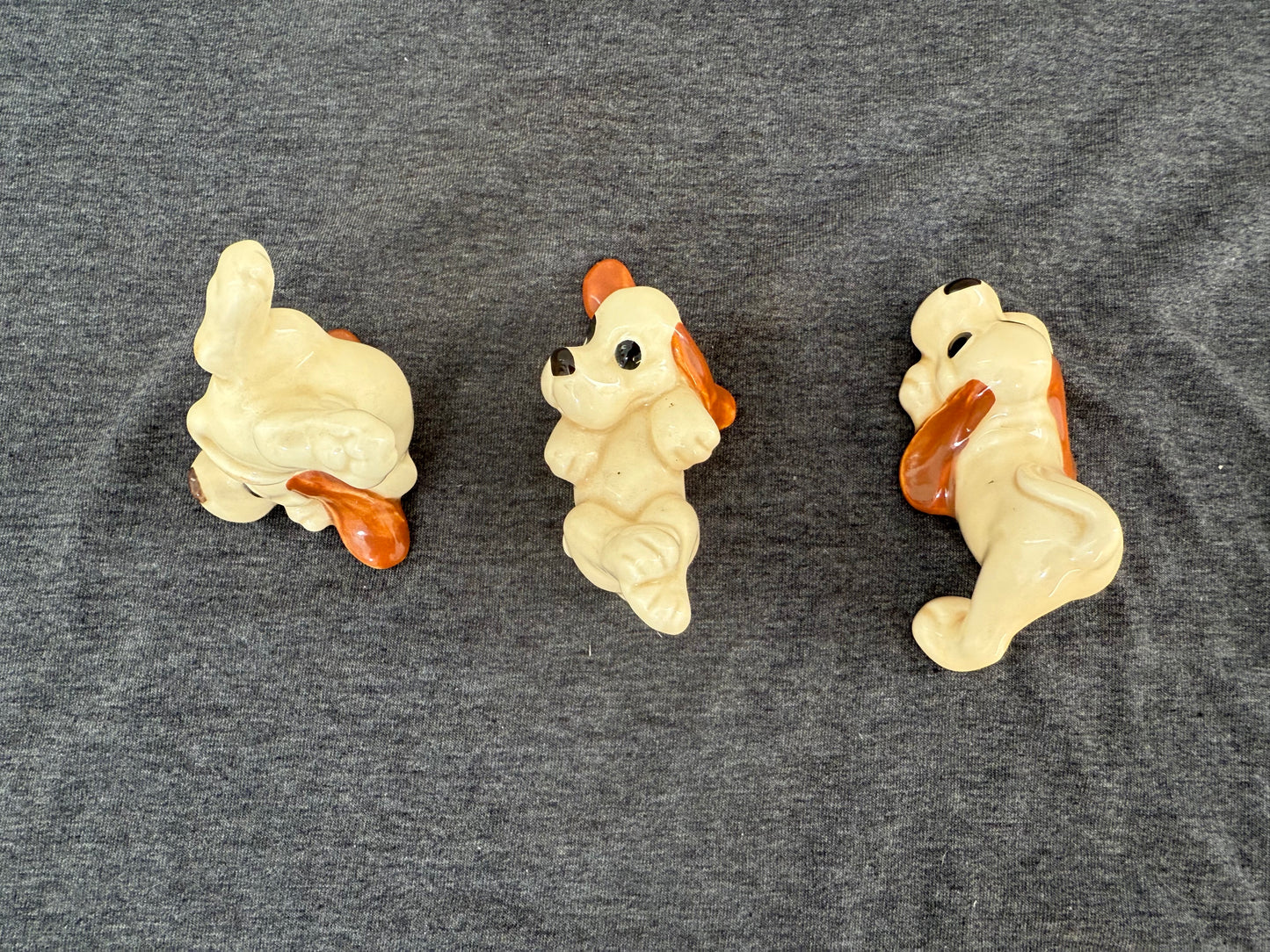 Three small dog figurines on a gray surface