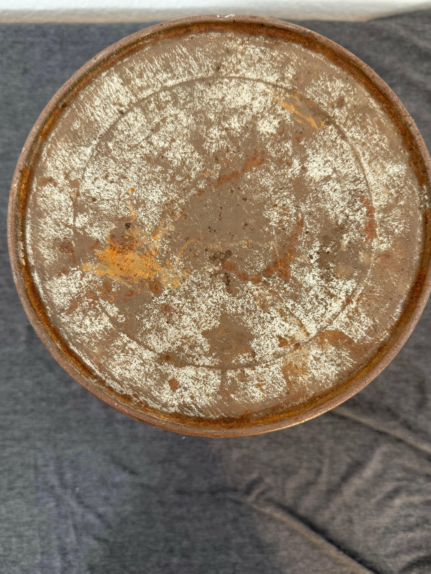 Rust-covered metal object on a textured gray background
