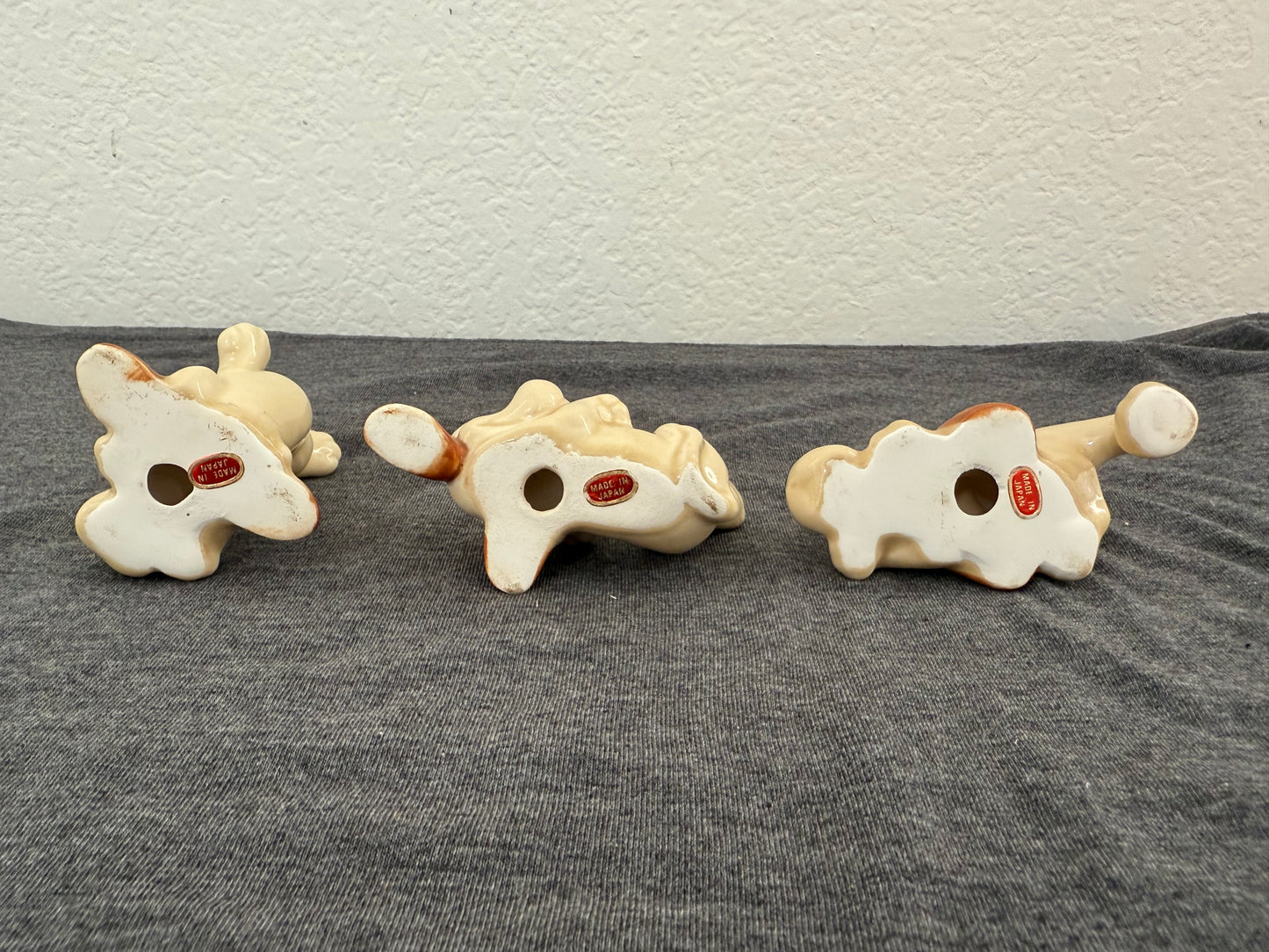 Three dog bone-shaped cookies with red centers on a gray surface.