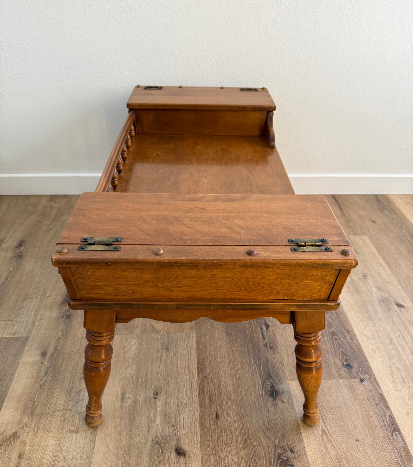 Wooden coffee table with two doors on a wooden floor against a white wall