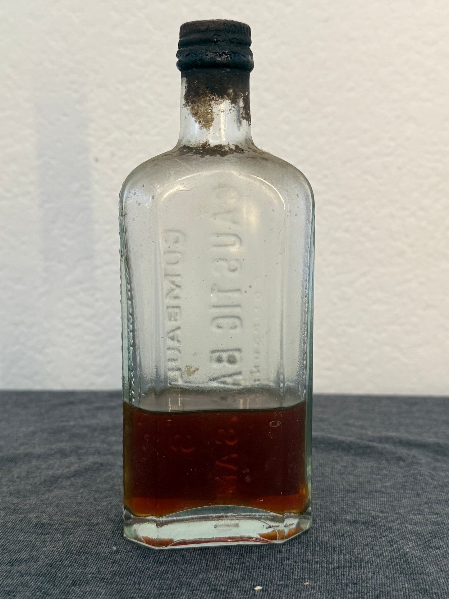 Vintage glass bottle with a cork stopper on a textured surface