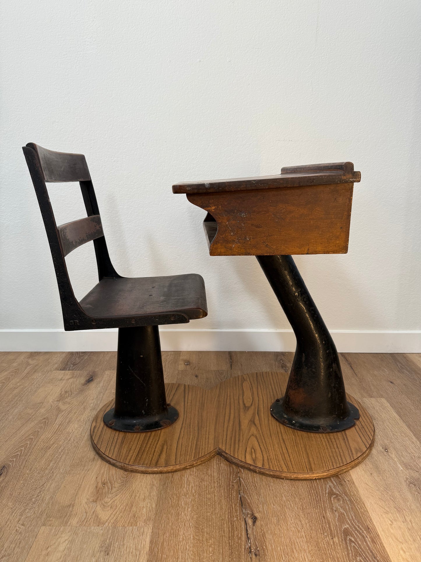 Antique wood school desk with cast iron legs on wooden base