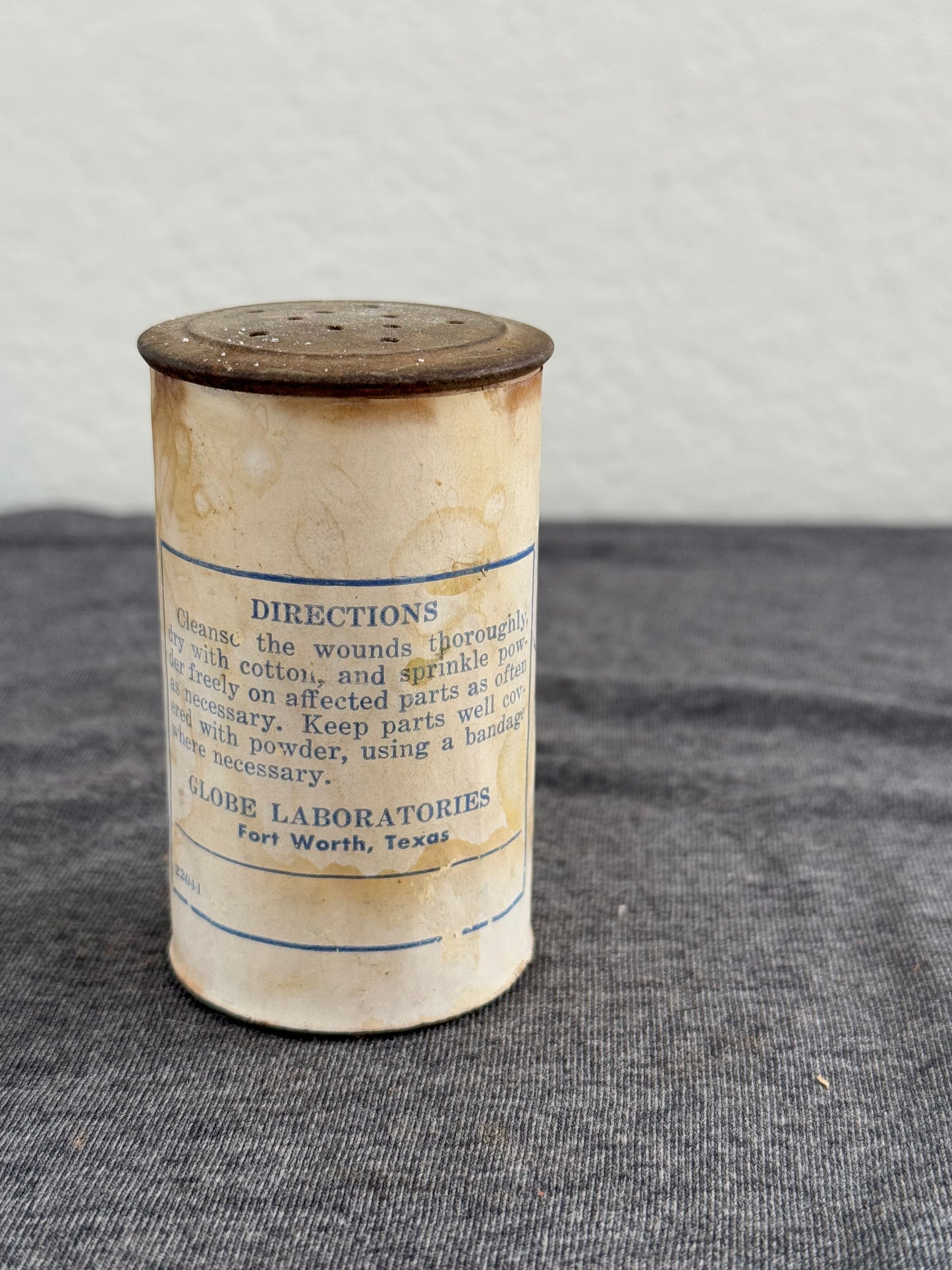 Cylindrical container with printed label on a gray surface
