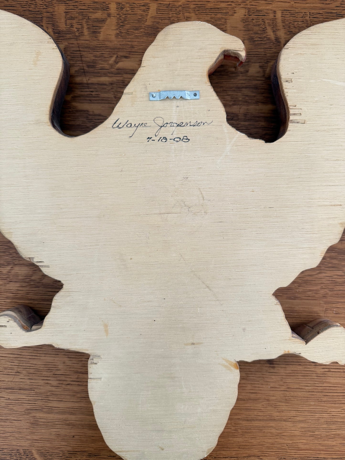 Wooden eagle with branding on a wooden surface