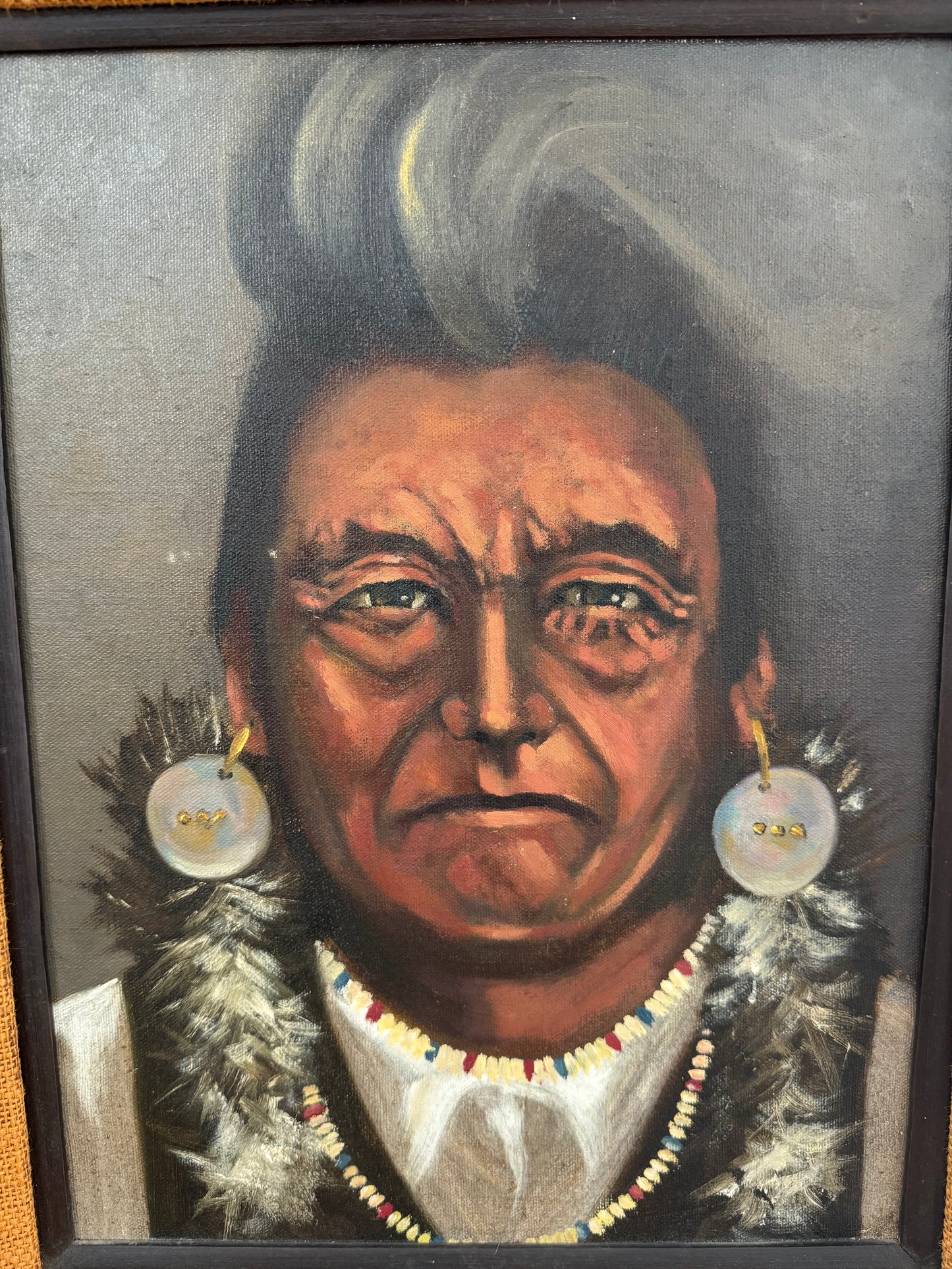 Portrait of a Native American Chief with earrings, necklace and beads.