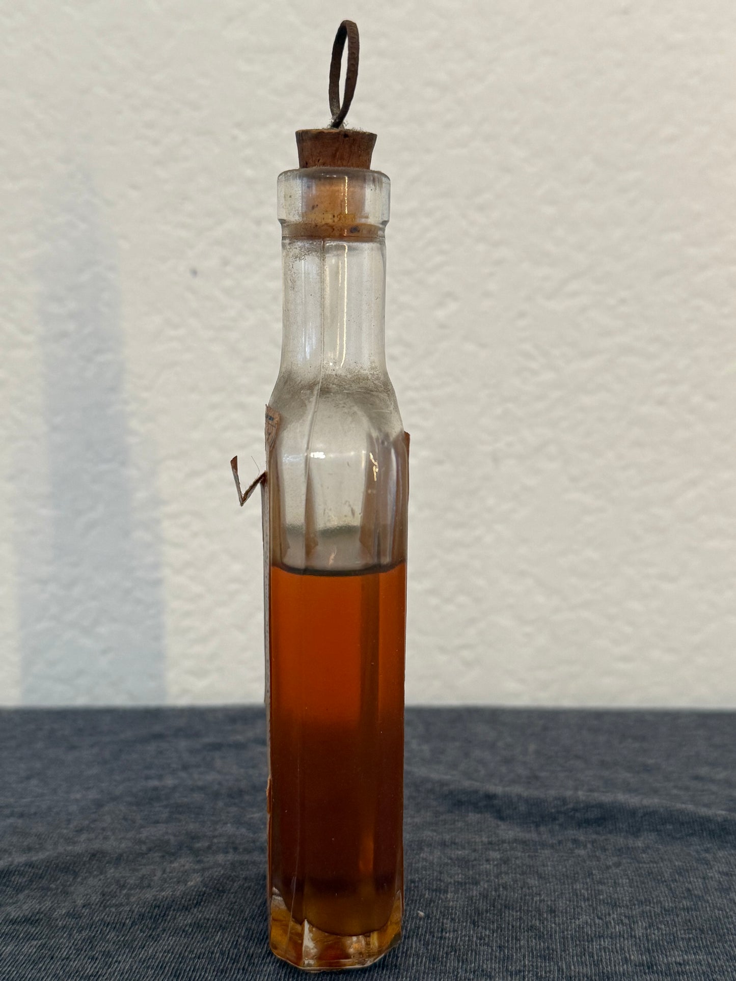 Glass bottle with a wooden cap on a textured surface