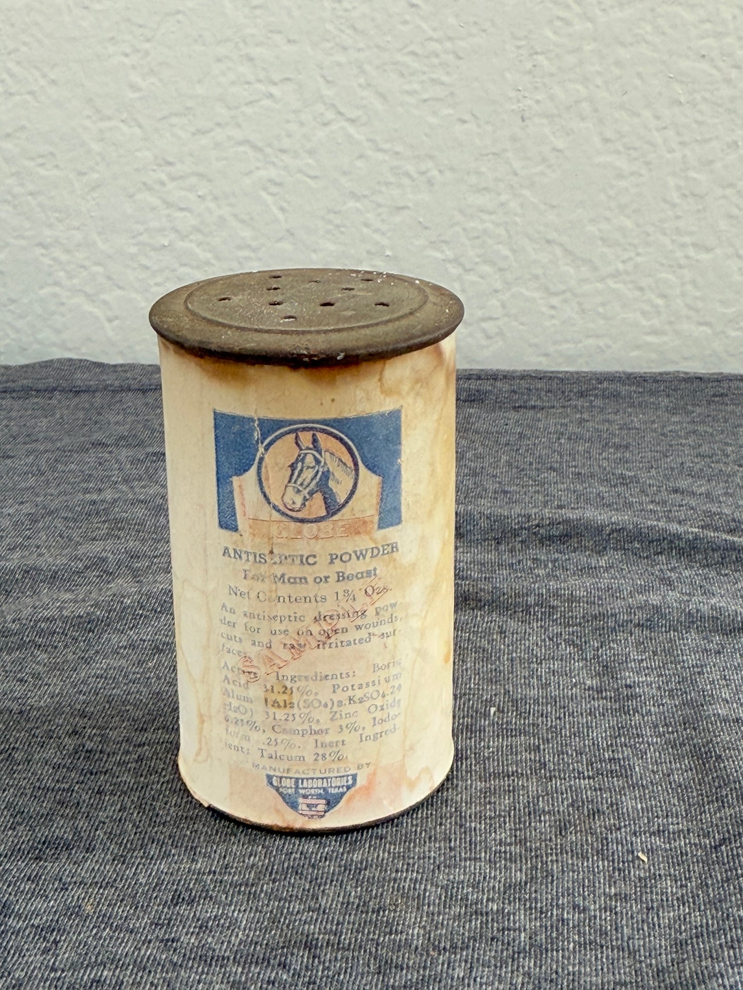 Cylindrical container with text on a gray surface