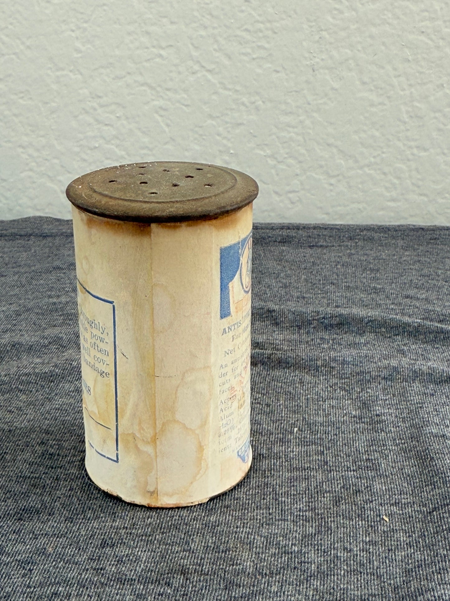 Cylindrical container with text on a gray surface