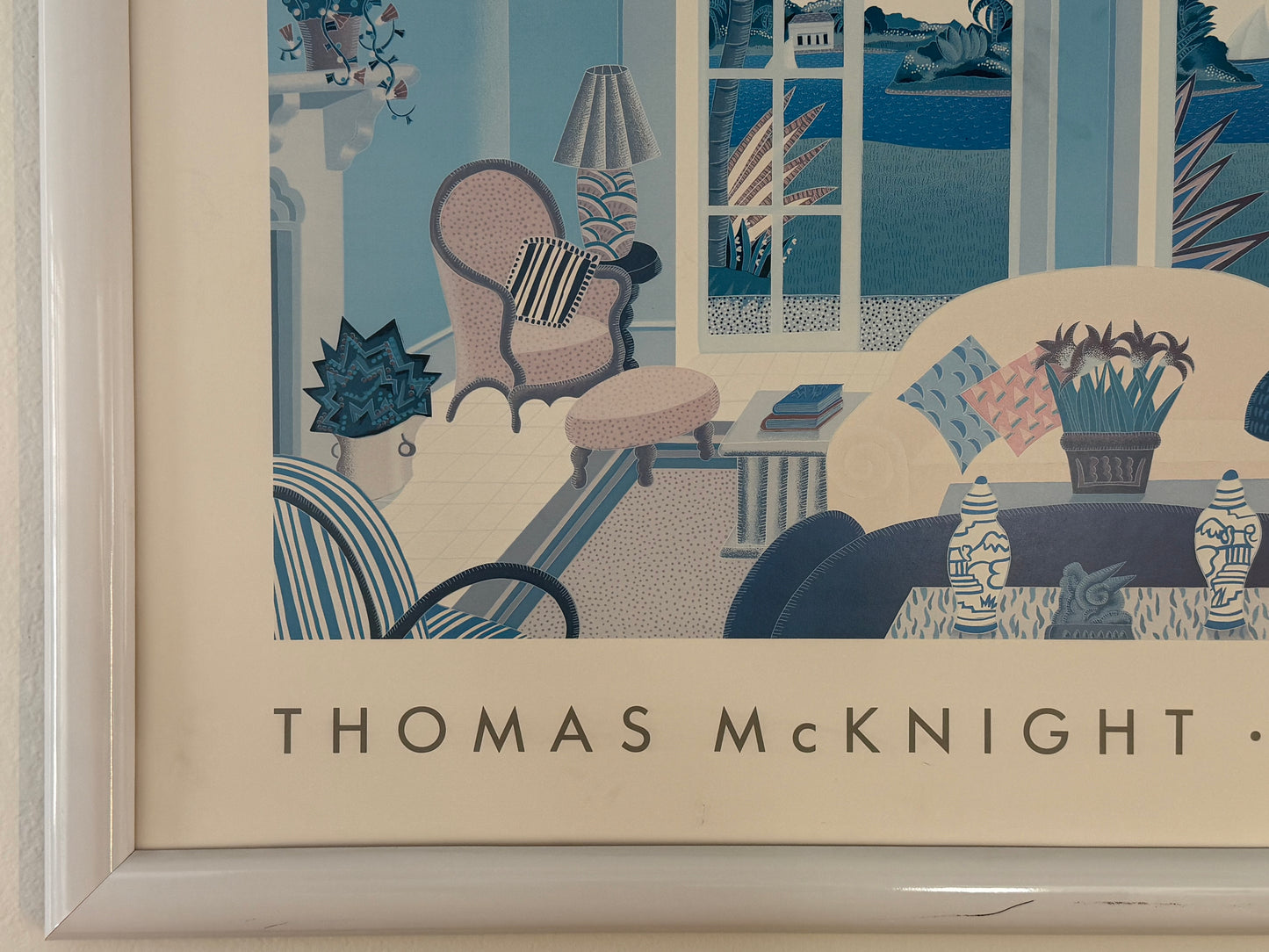 Framed artwork by Thomas McKnight depicting a living room scene with furniture and decor.
