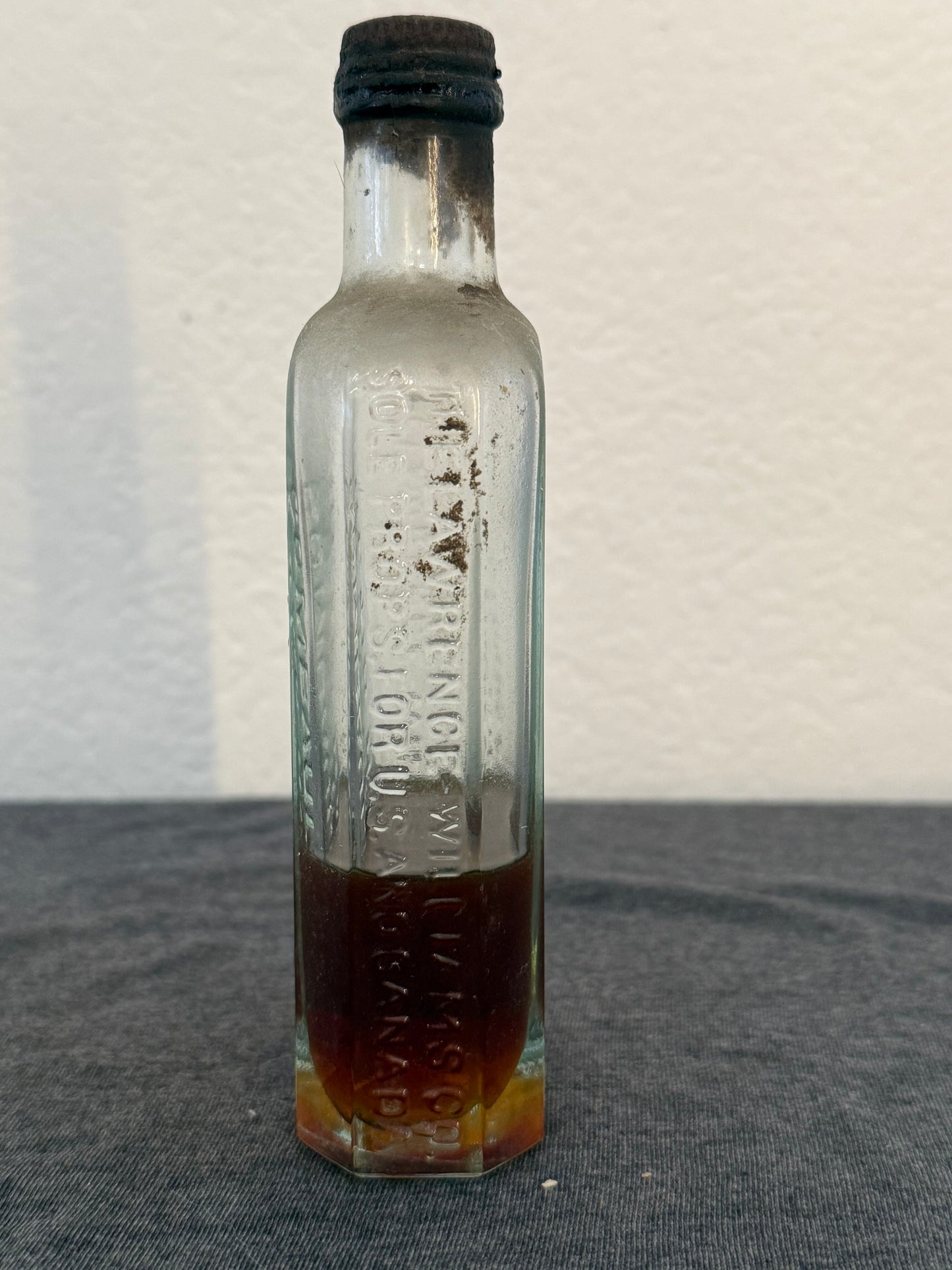 Vintage glass bottle with writing on a light background