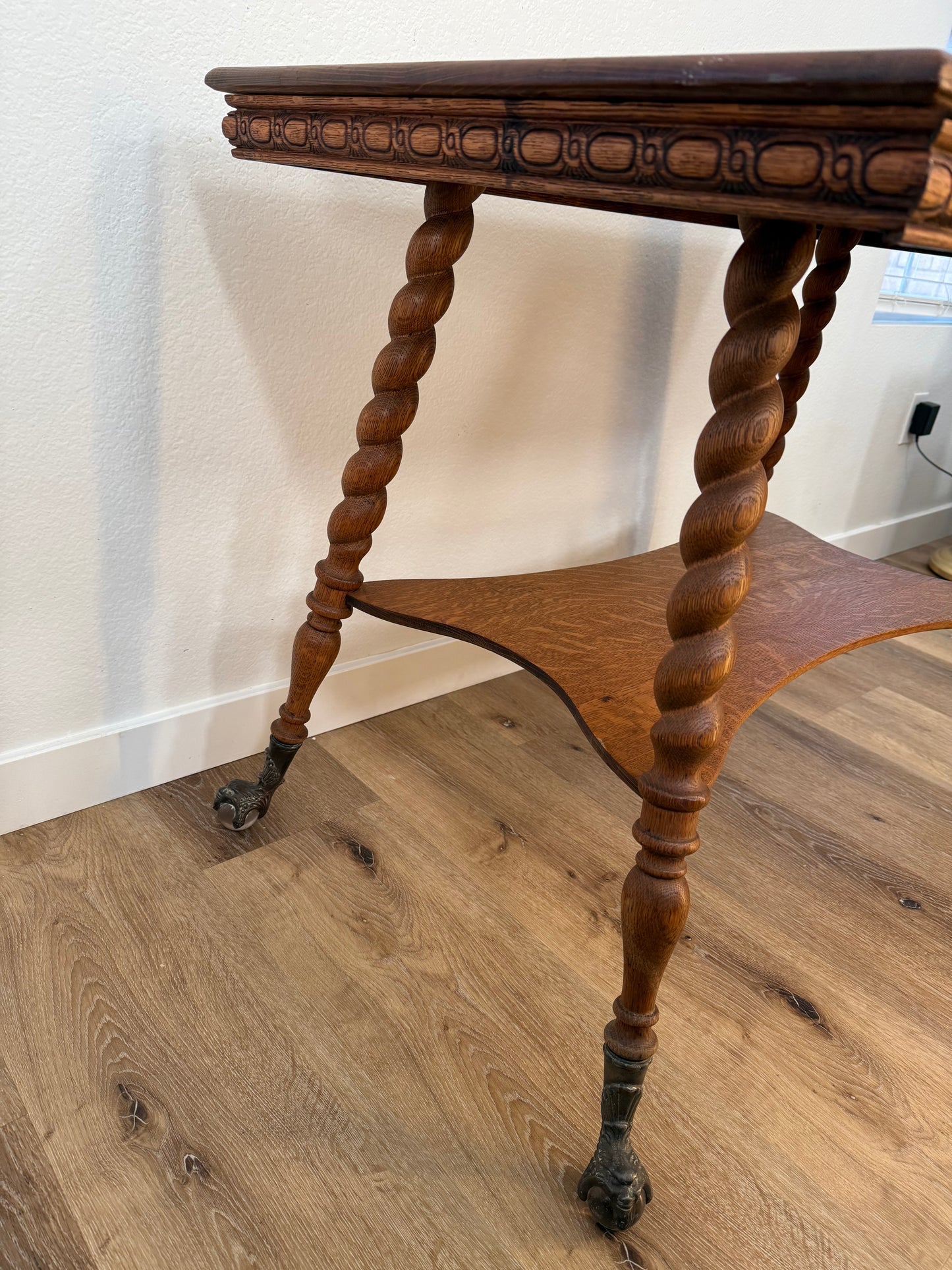 Close-up of a wooden table with twisted legs on a wooden floor.