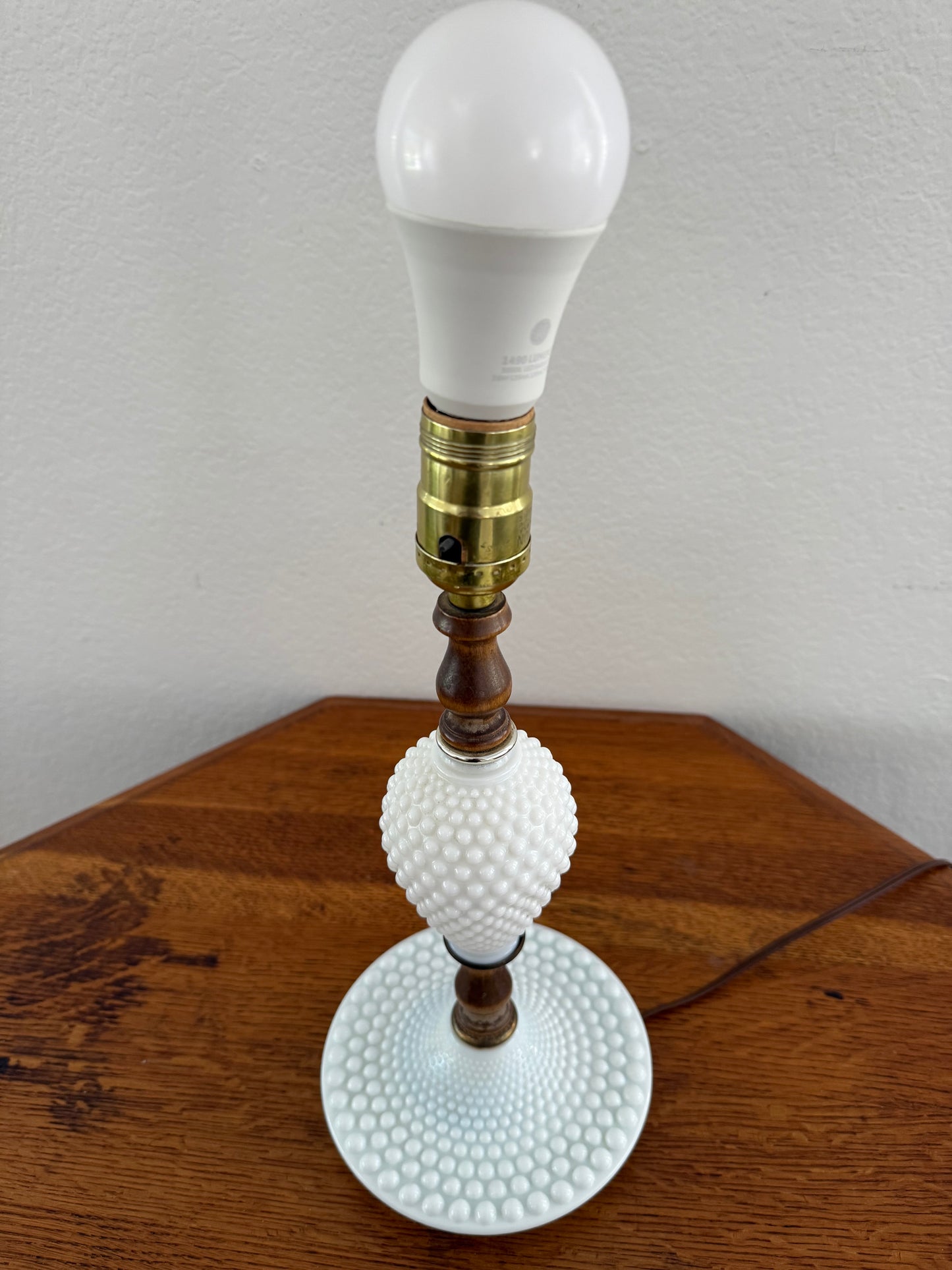 Light bulb with decorative holder attached to a wooden surface