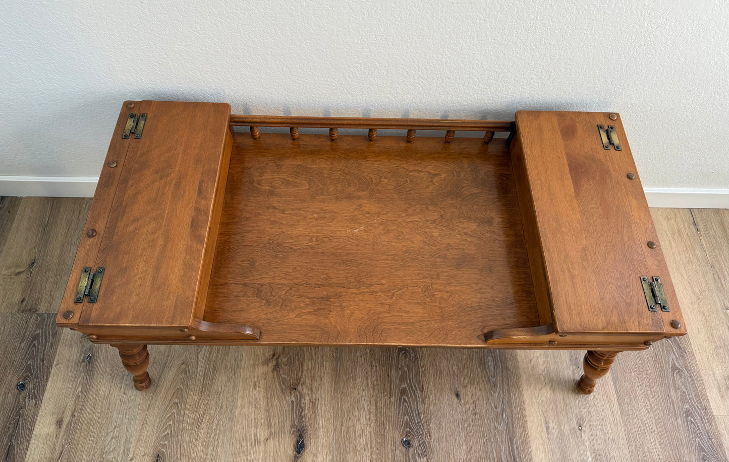 Wooden coffee table with doors on each end sitting on a wooden floor