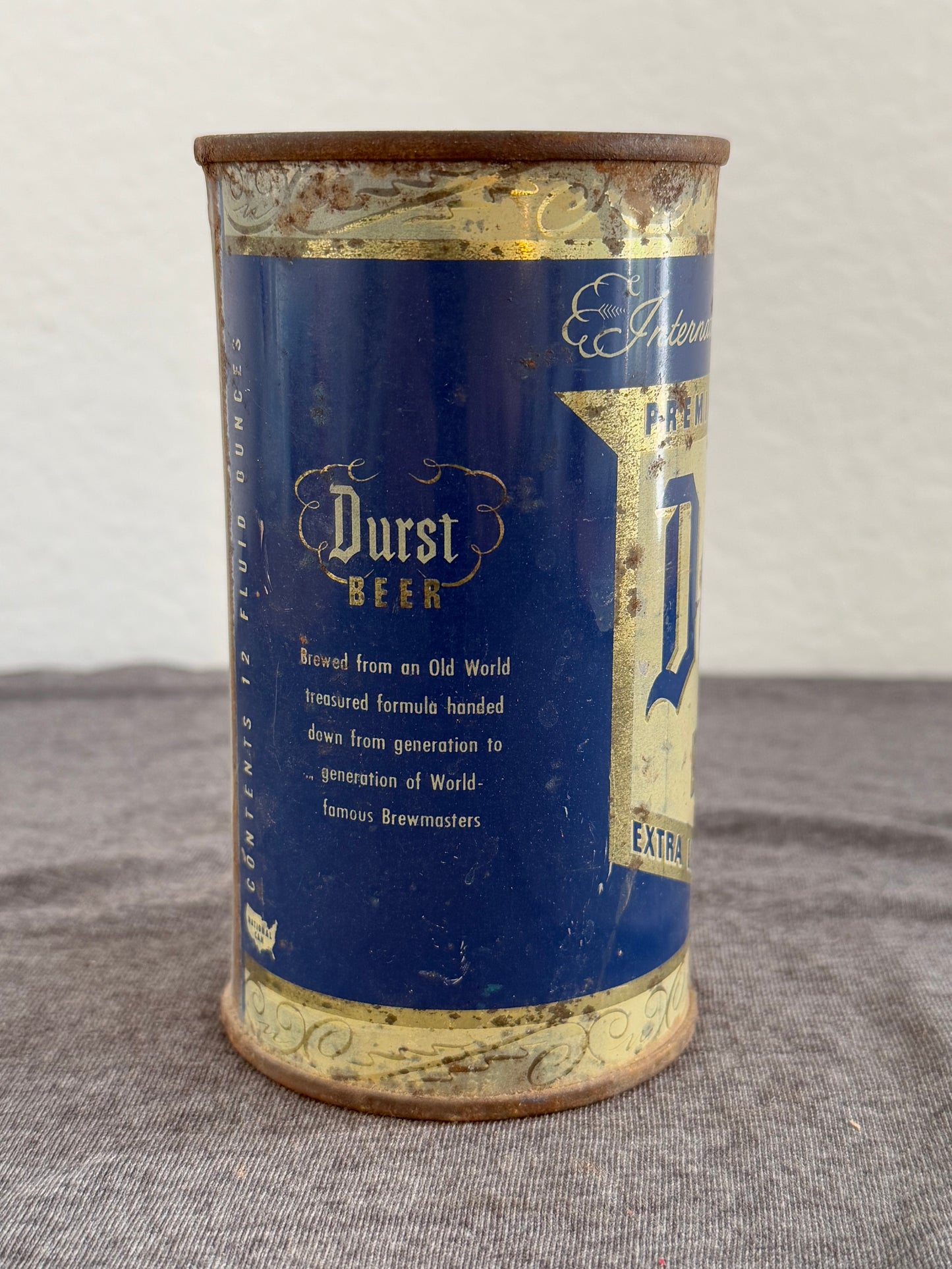 Vintage blue and gold beer can on a gray surface