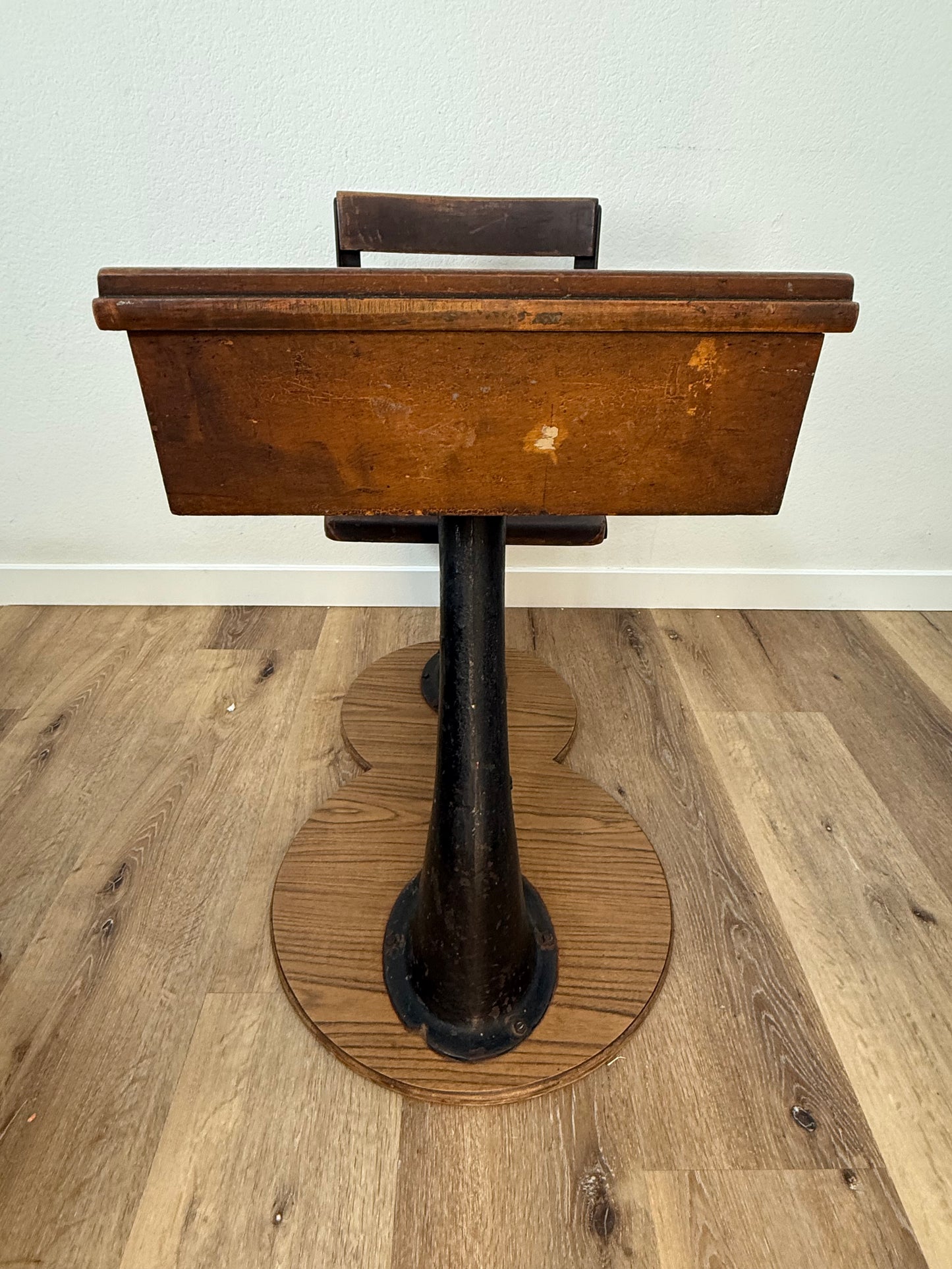 Antique wood school desk with cast iron legs on wooden base