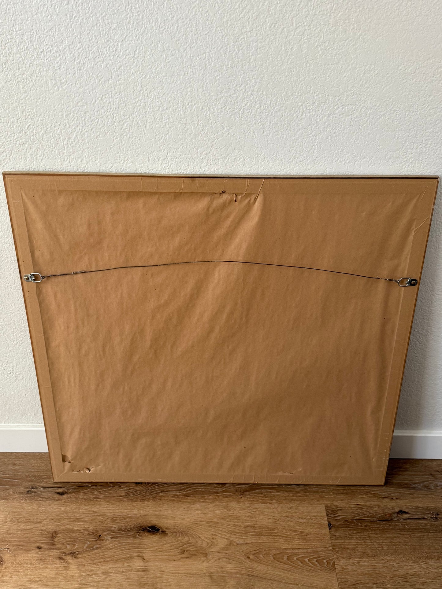 back of wooden frame against a white wall.