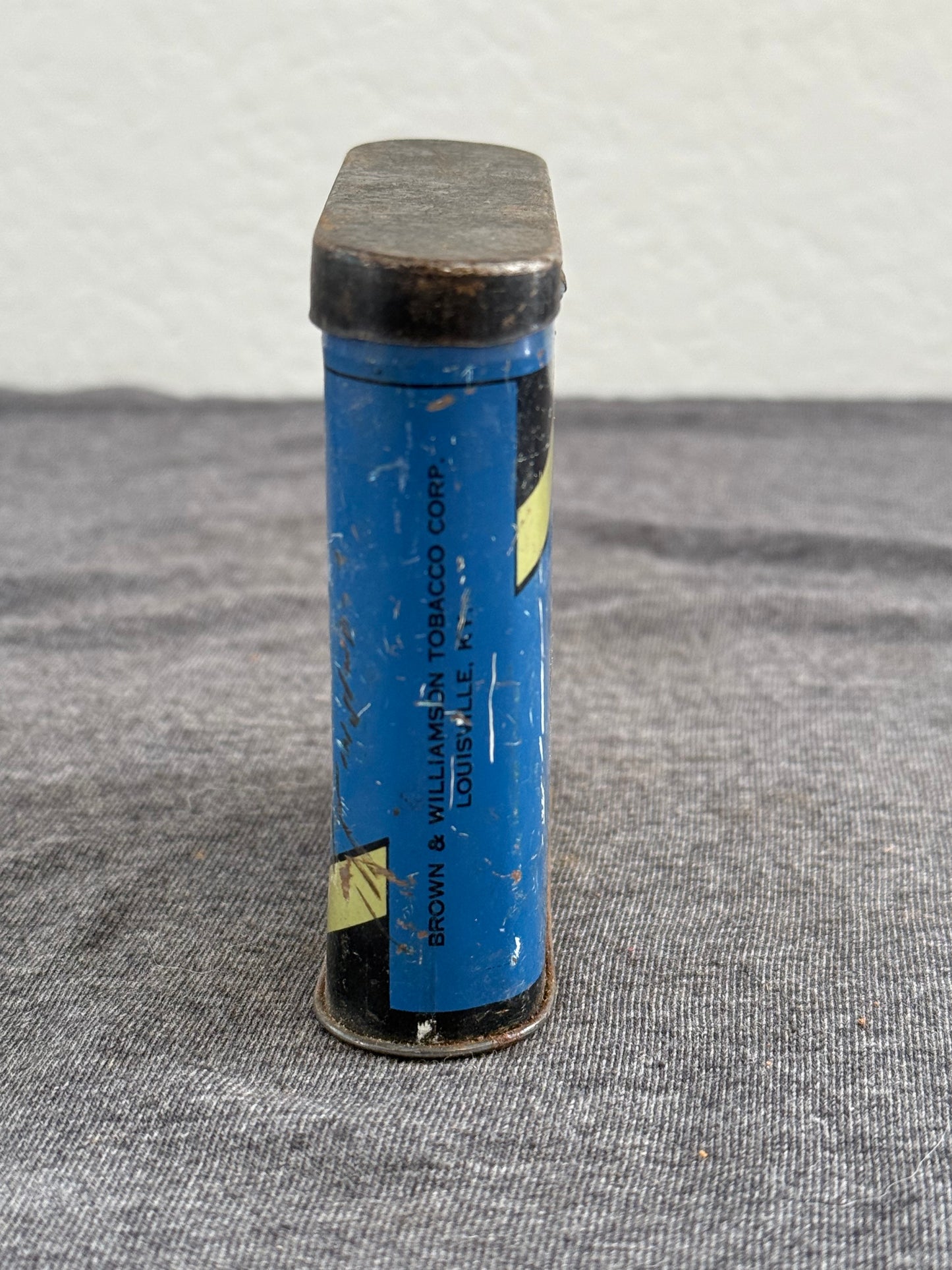 Blue cylindrical case with text on a gray surface
