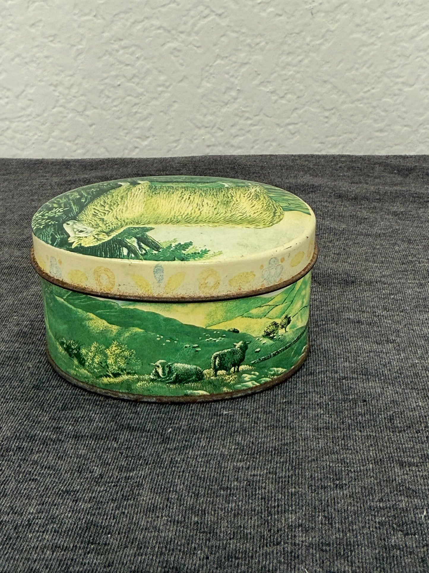 Decorative wooden box with green and beige pattern on a gray surface