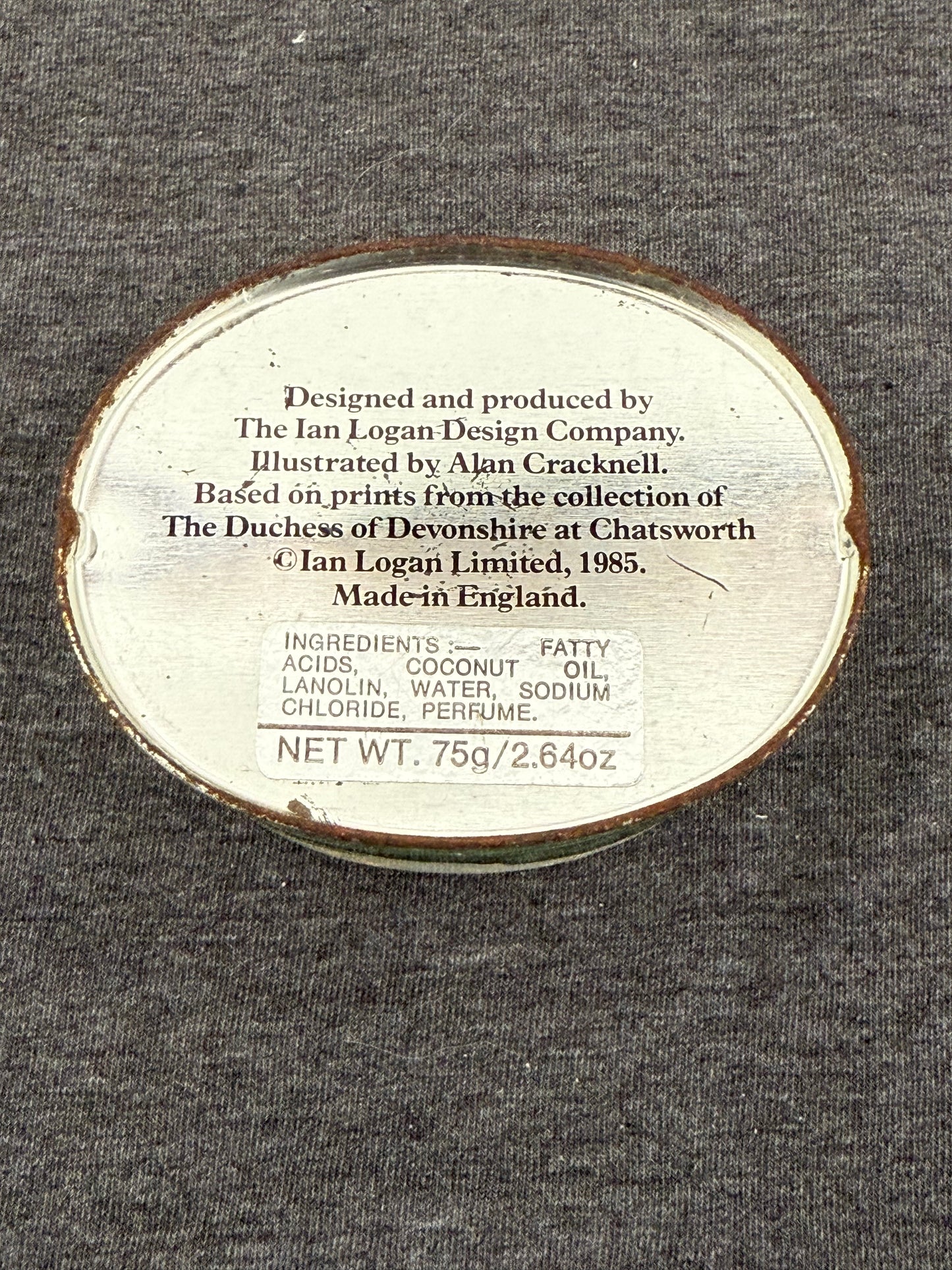 Round metal label with text on a gray background