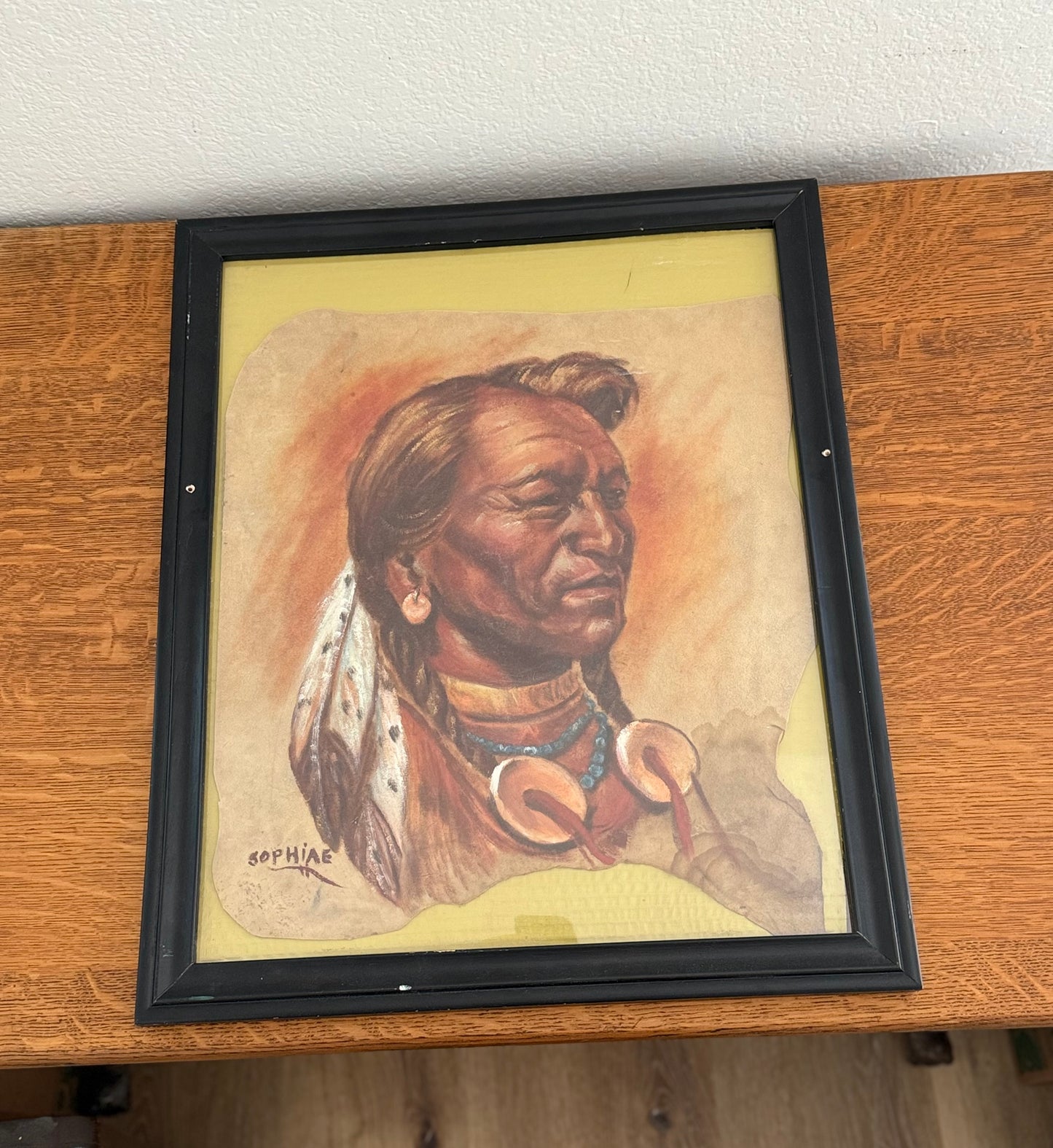 Framed painting of Native American on wood table