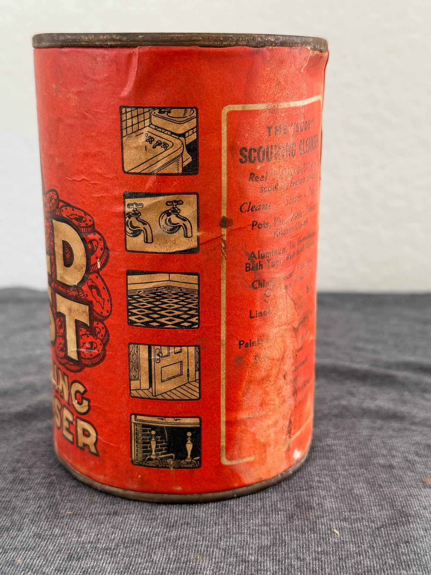 Vintage red canister with black text and graphics on a gray surface