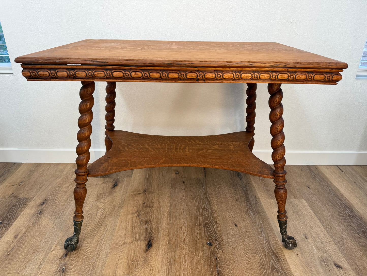 Wooden parlor table with intricate carvings on a wooden floor