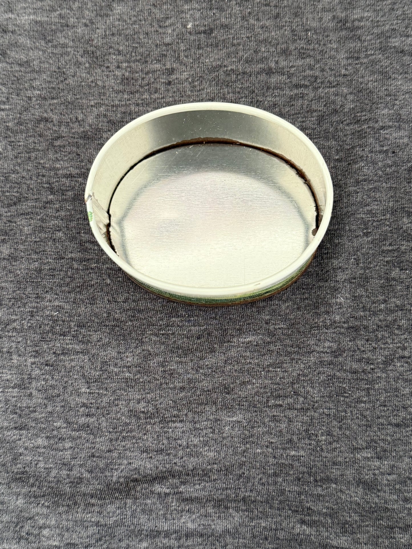 Round metallic object on a textured gray surface