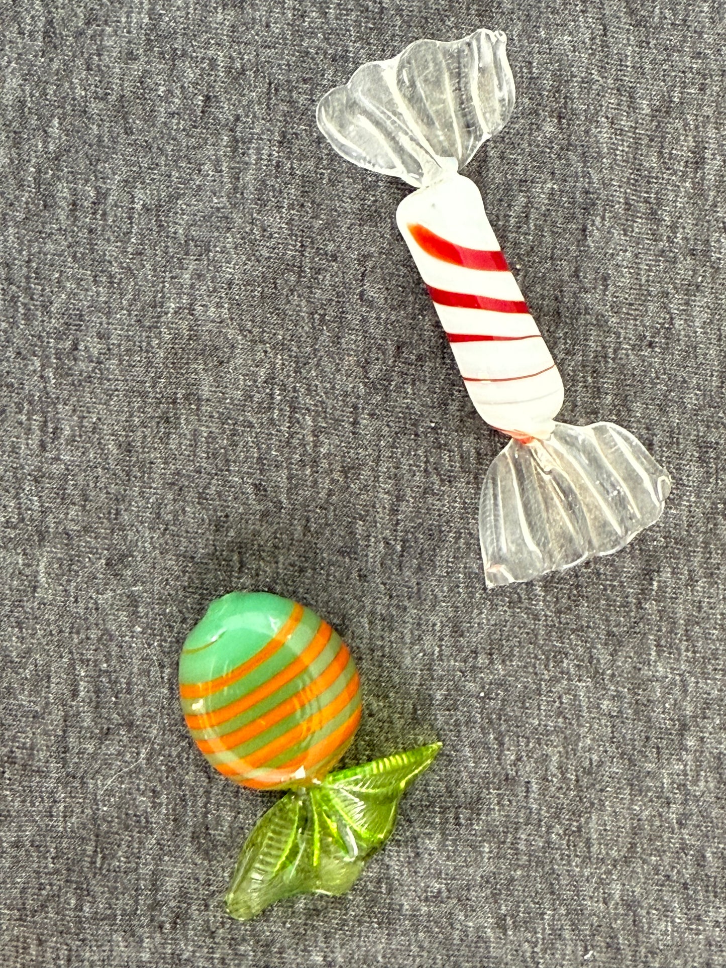 Two glass candy figurines on a gray background