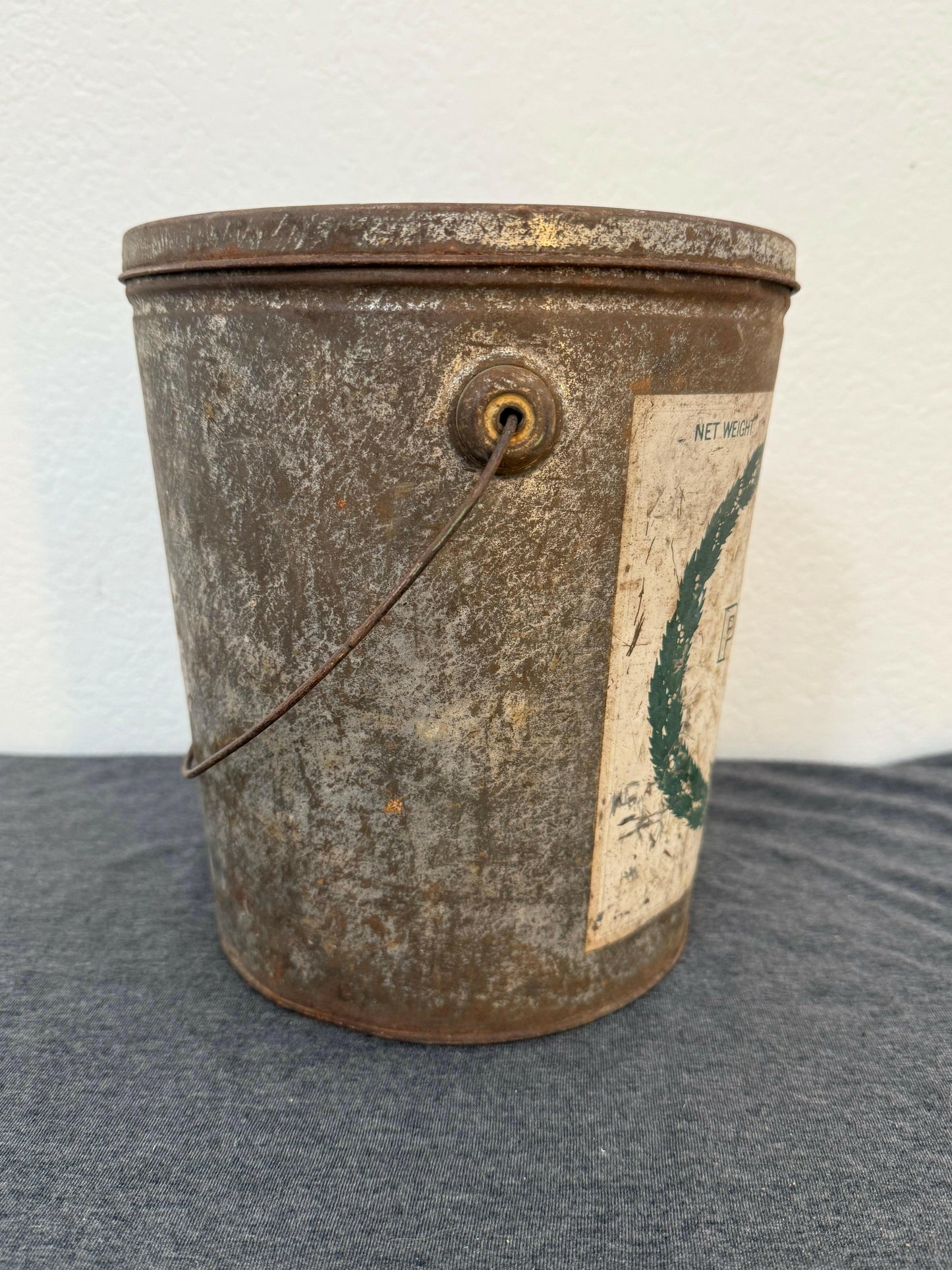 Vintage metal canister with a label on a gray background