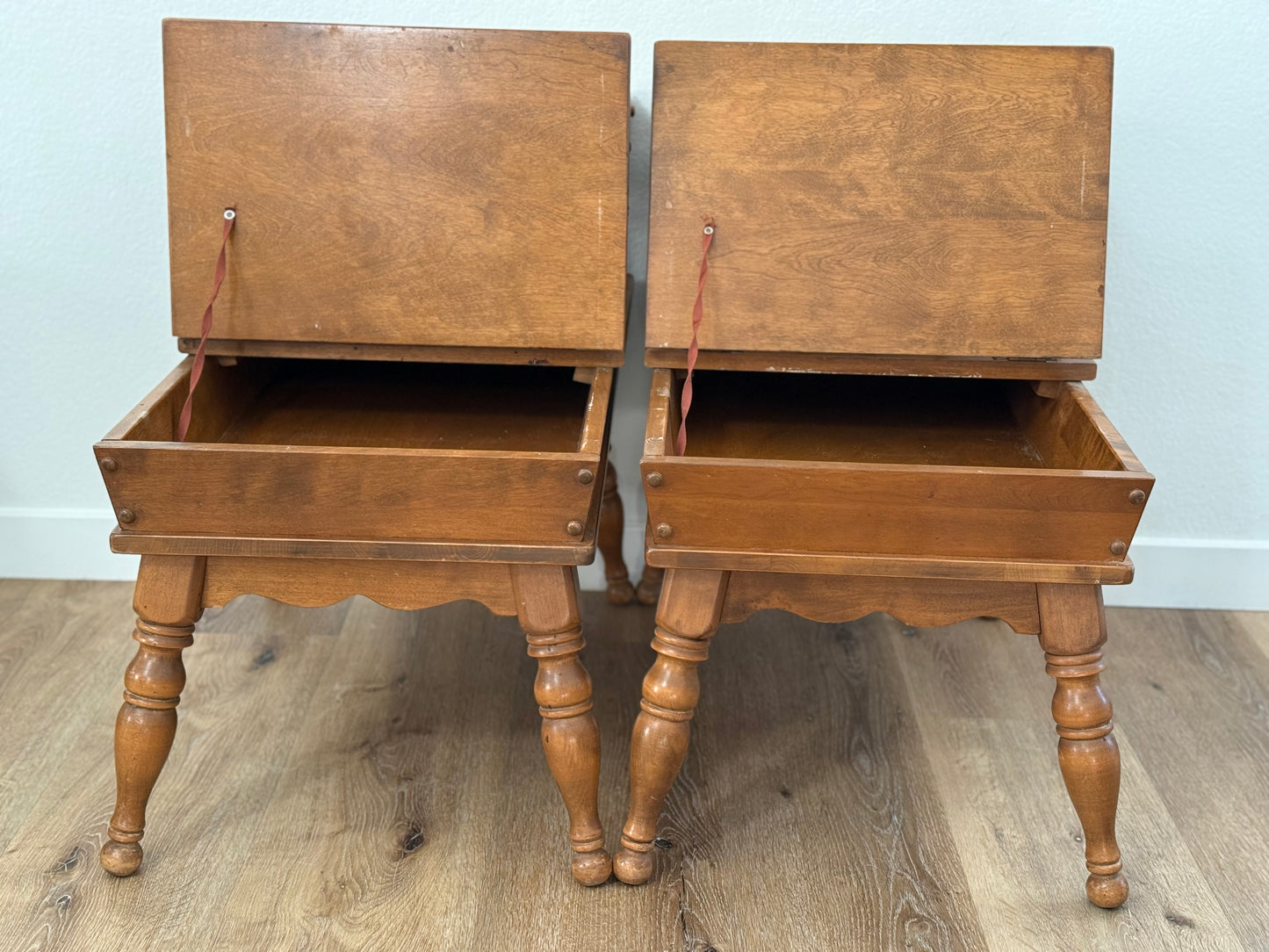 Pair of wooden side tables with open tops on a wooden floor.