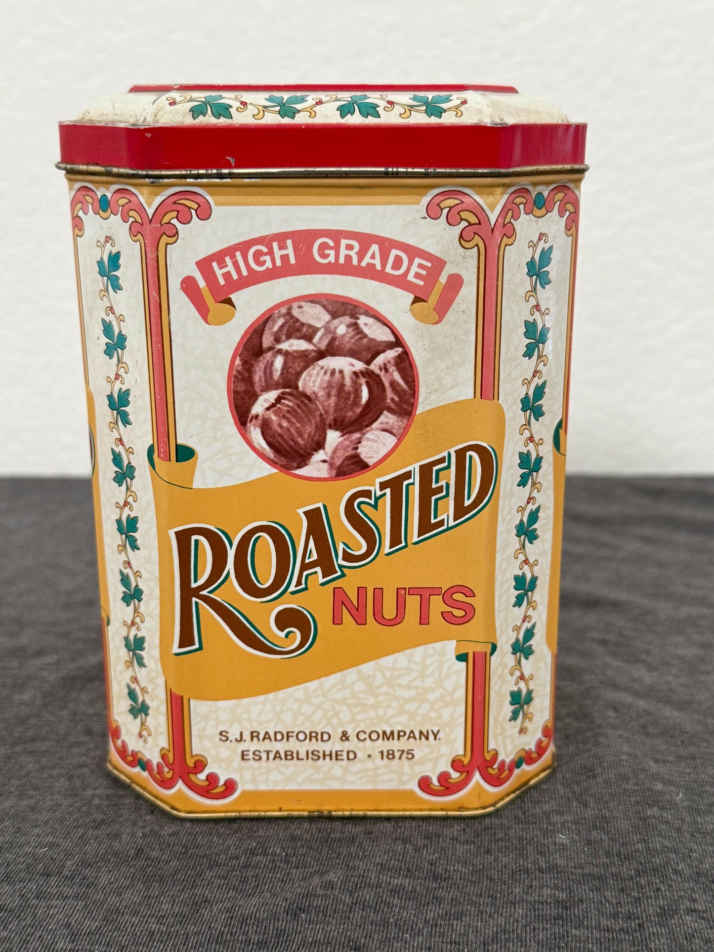 Vintage-style packaging of roasted nuts with decorative design on a gray surface.