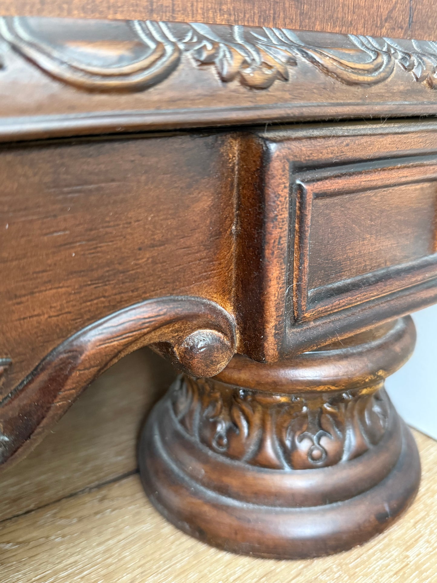 Decorative wooden leg on dresser with intricate carvings