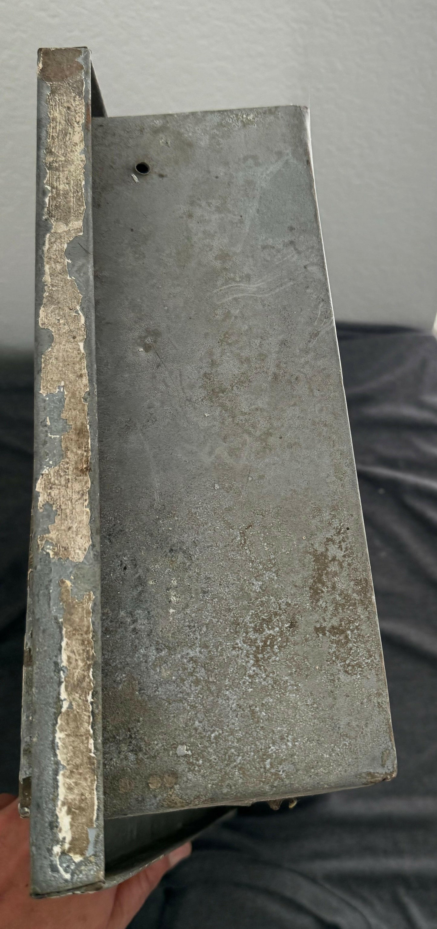 Rust-covered metal block on a gray background