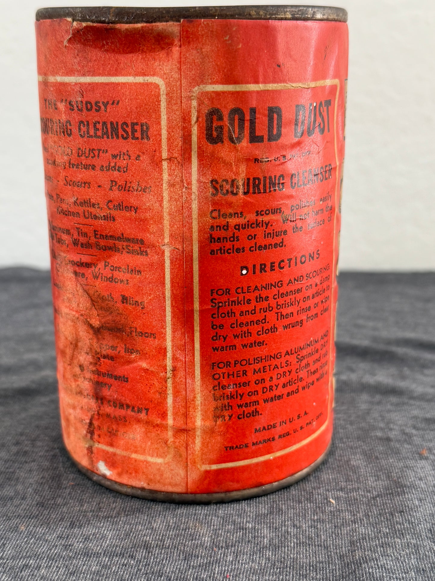 Vintage red canister with text on a gray fabric background