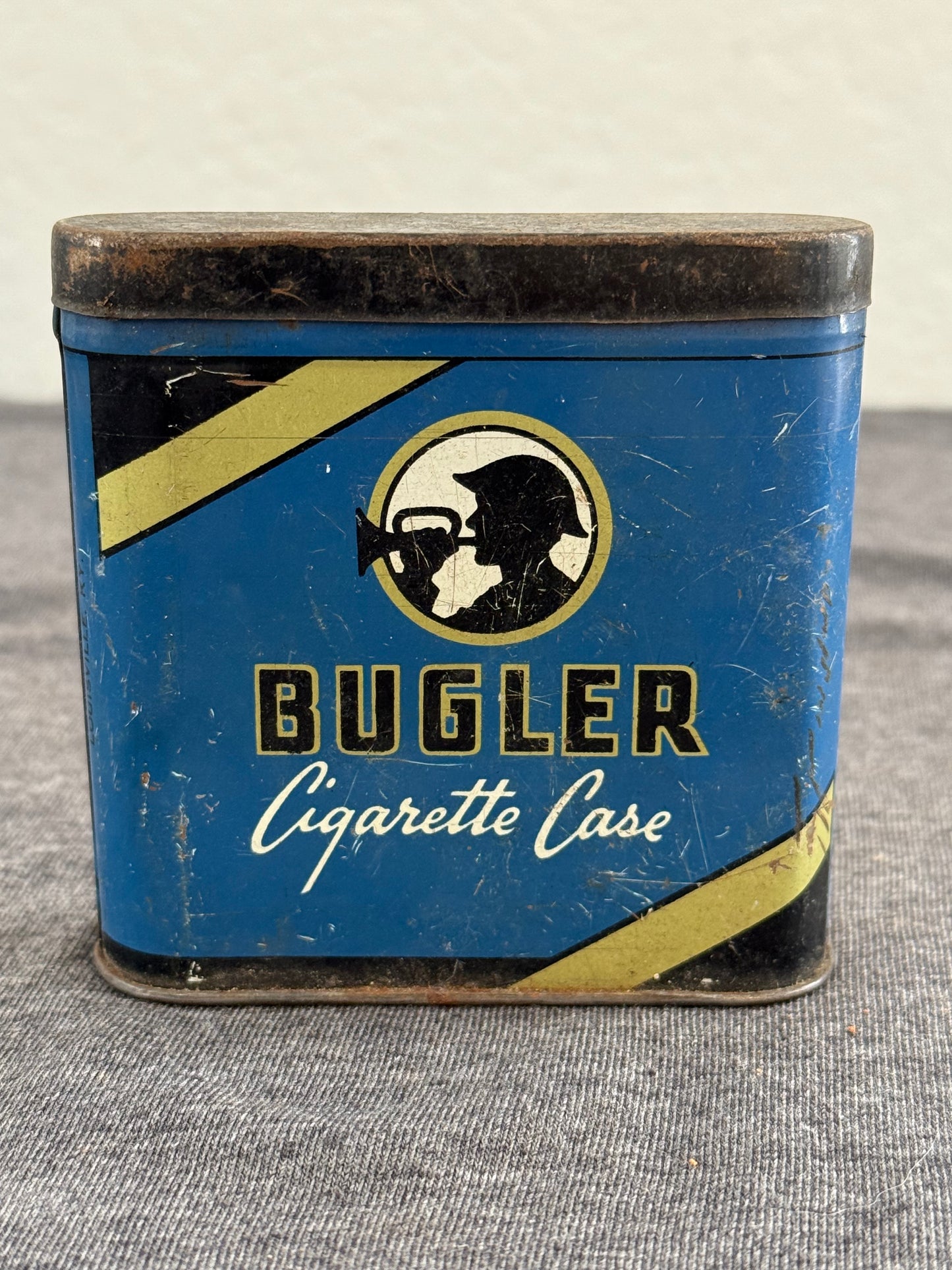 Vintage Bugler cigarette case with blue and black design on a textured surface