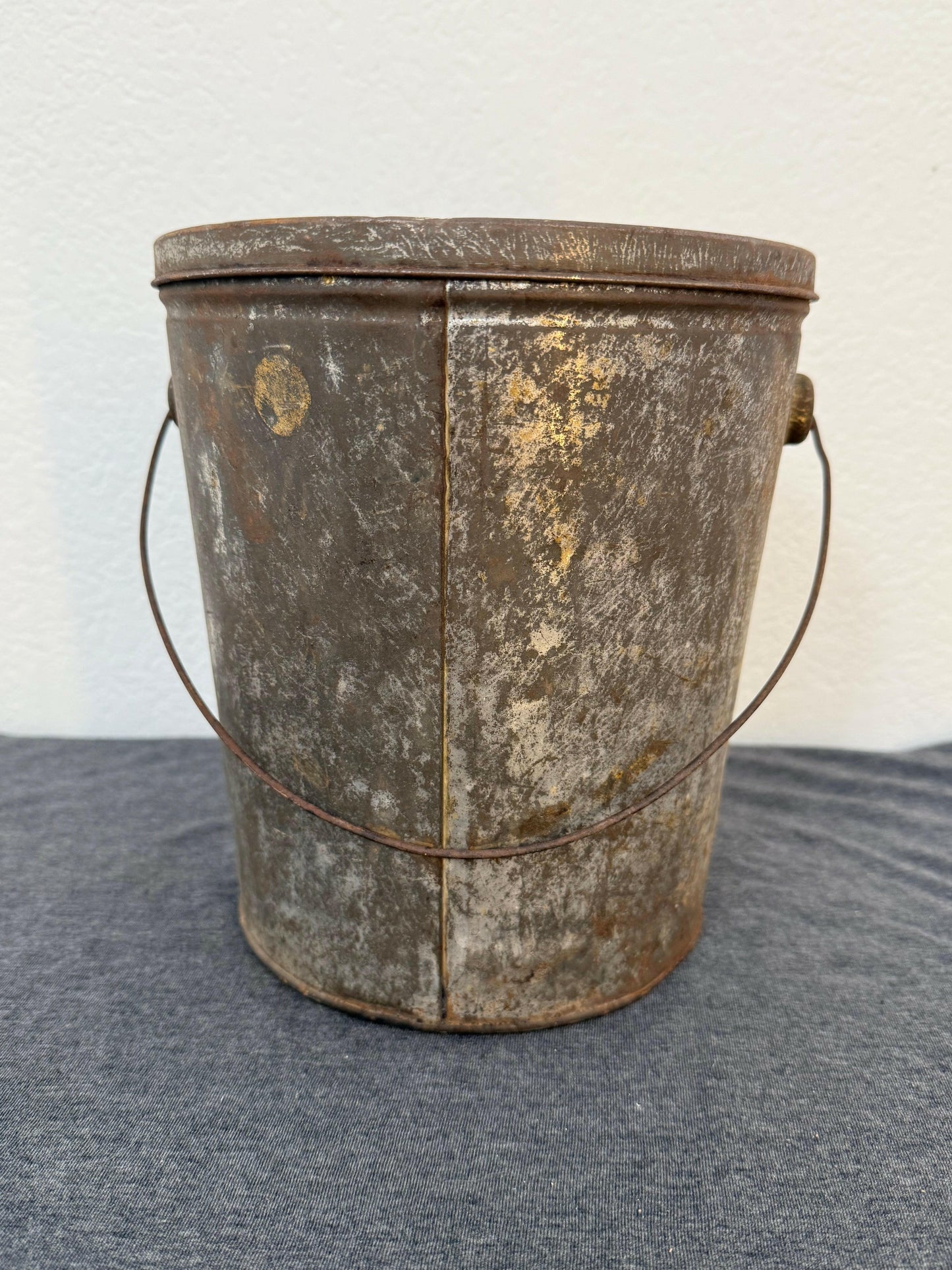 Vintage metal bucket with a handle on a light gray background