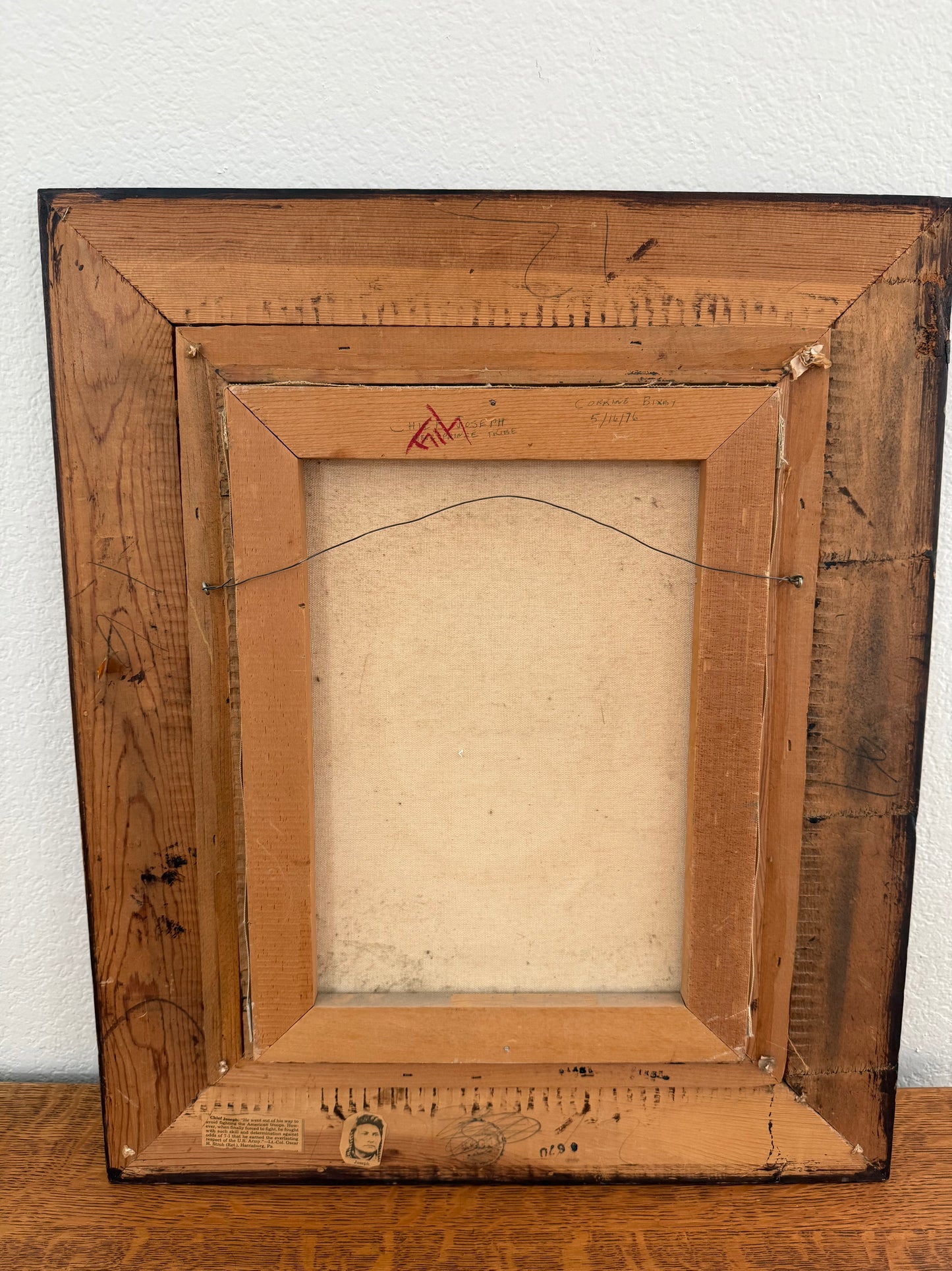 Backside of wooden picture frame on a white wall