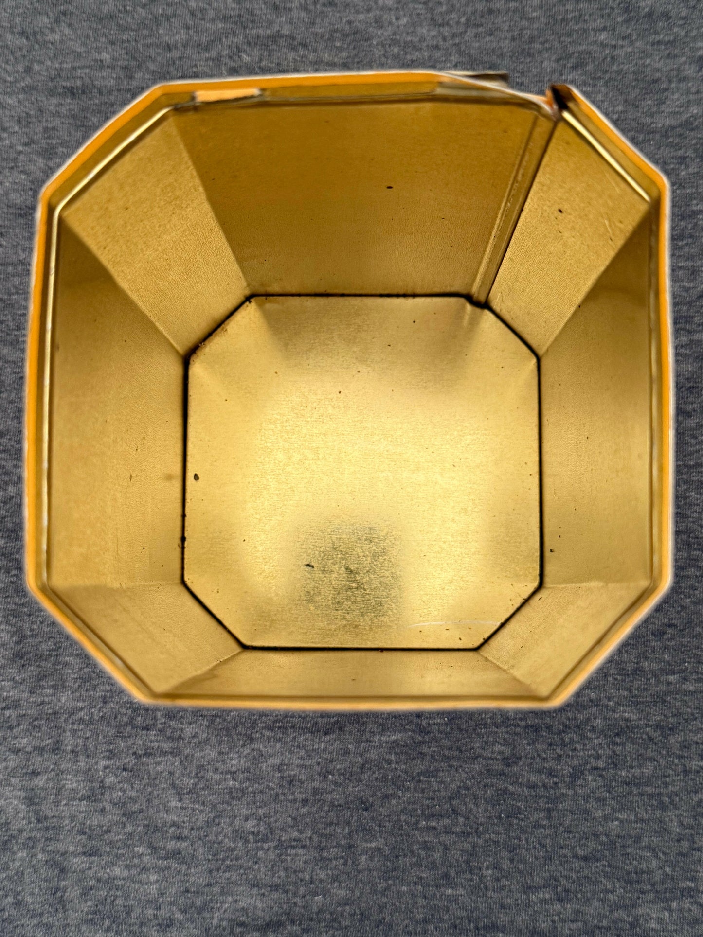 Gold-colored octagonal container on a gray background
