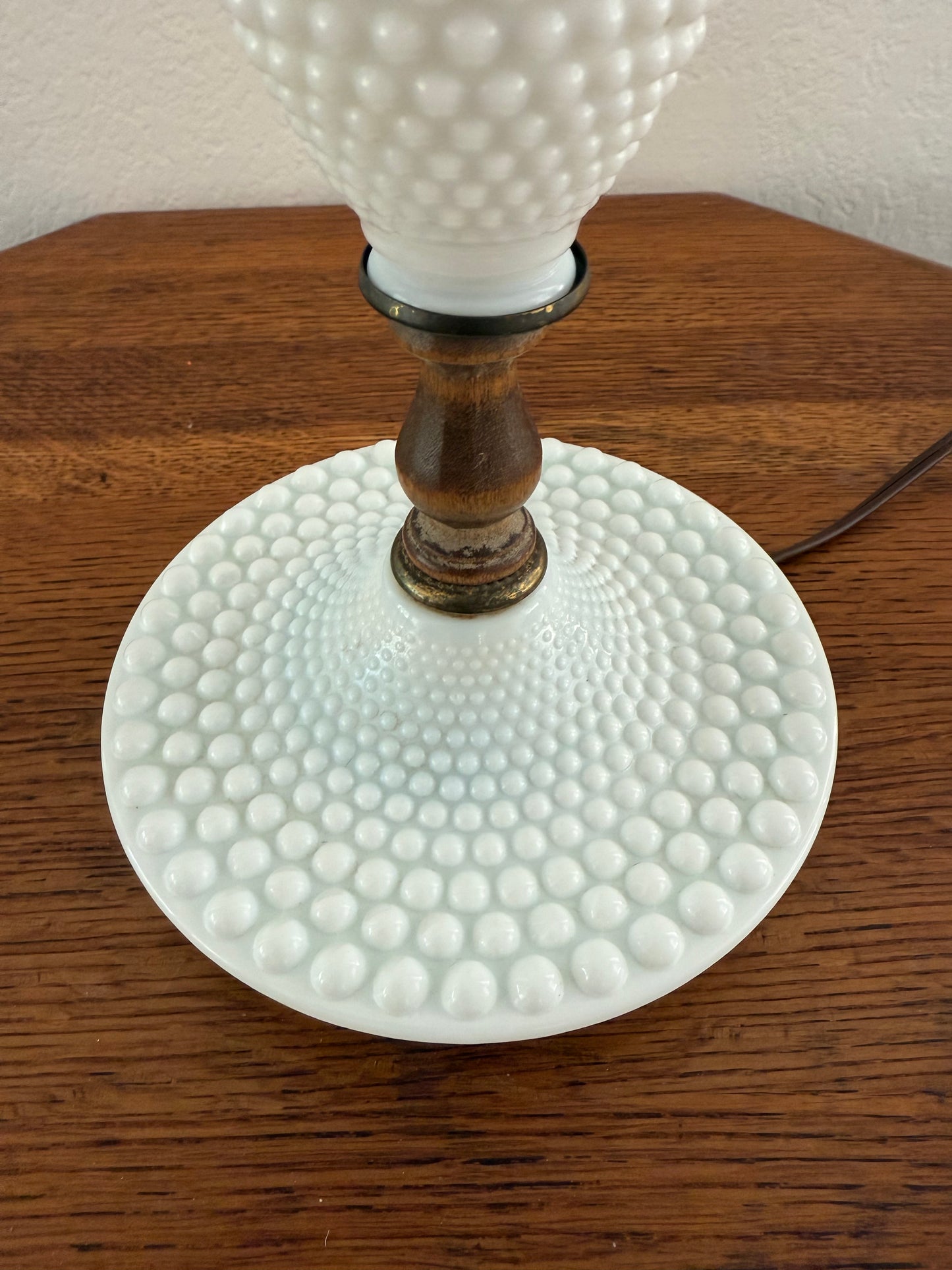 Close-up of a textured white glass lamp on a wooden surface