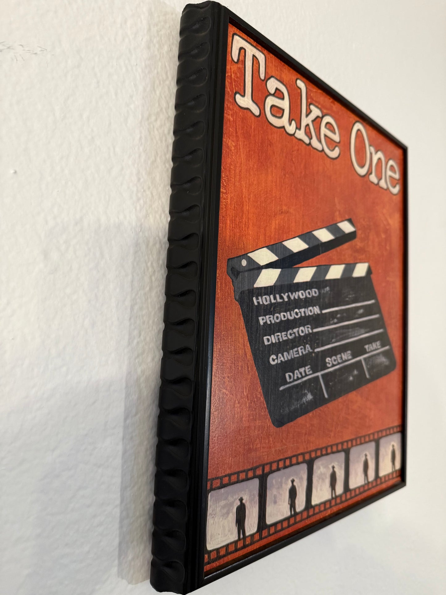 Decorative box with clapperboard design and 'Take One' text on a white surface