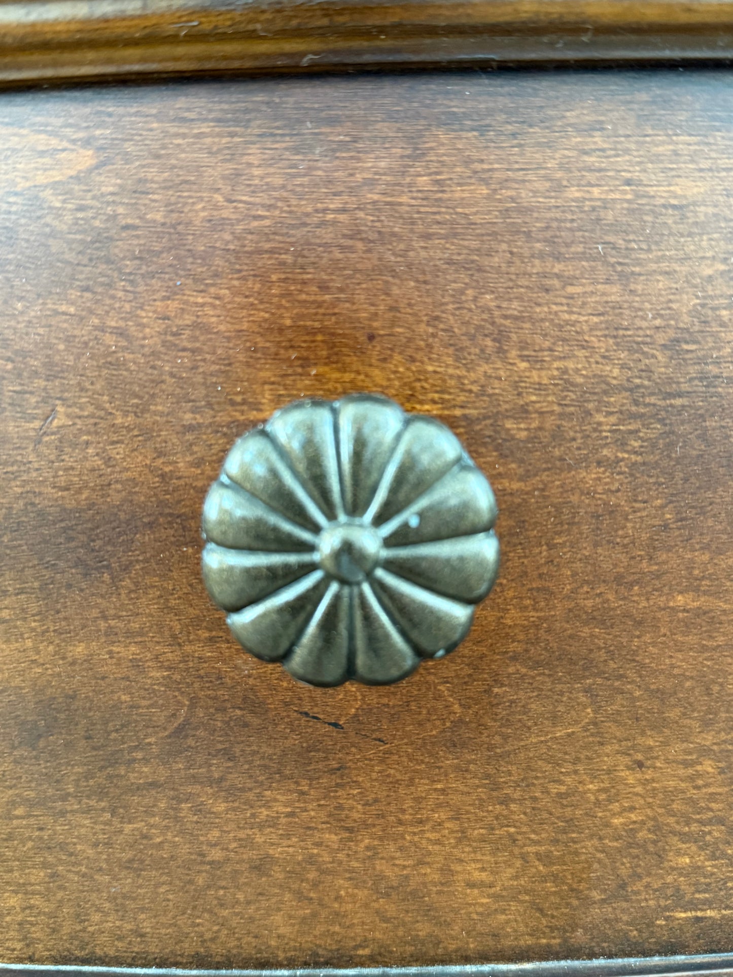 Decorative metal knob on a wooden dresser